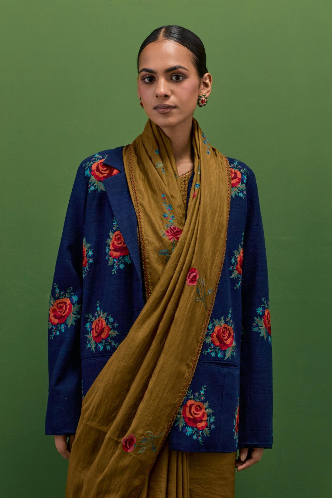 Golden olive silk saree with all-over thread embroidered roses and scalloped organza with delicate bead detail at the edges, paired with golden olive silk blouse with all-over pin tucks, highlighted with bead work.