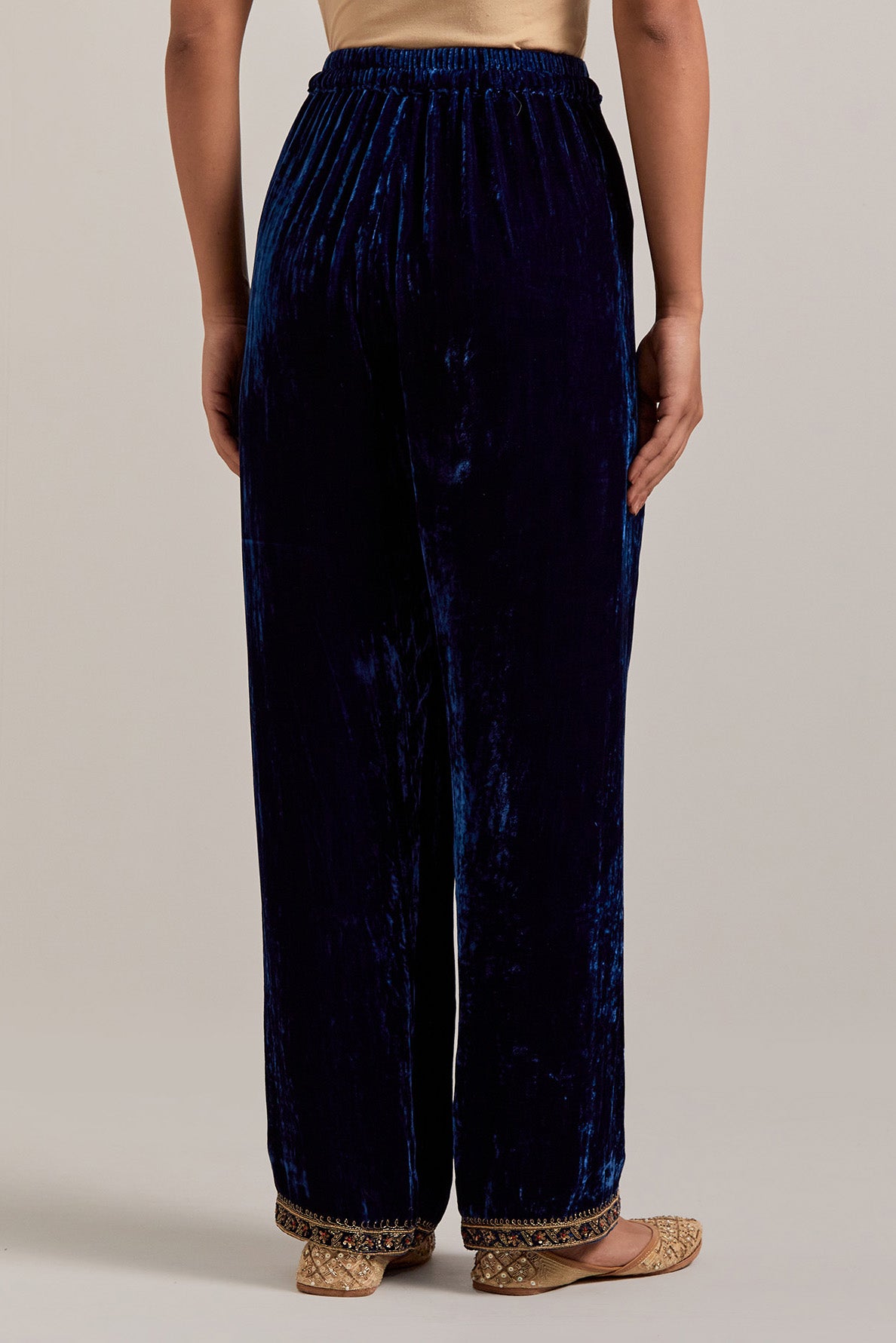 Navy blue Silk velvet pants, highlighted with hand embroidered bead, sequins, zardozi and zari narrow border at bottom hem.