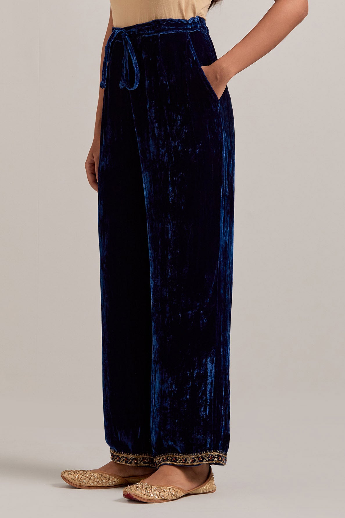 Navy blue Silk velvet pants, highlighted with hand embroidered bead, sequins, zardozi and zari narrow border at bottom hem.