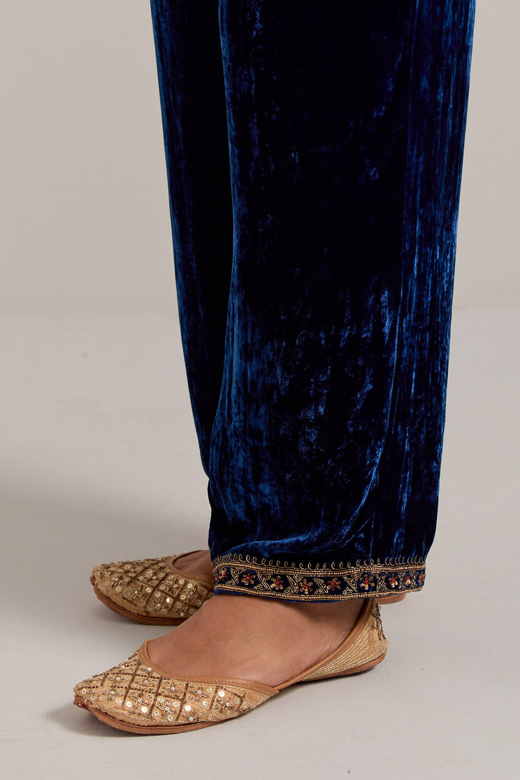 Navy blue Silk velvet pants, highlighted with hand embroidered bead, sequins, zardozi and zari narrow border at bottom hem.