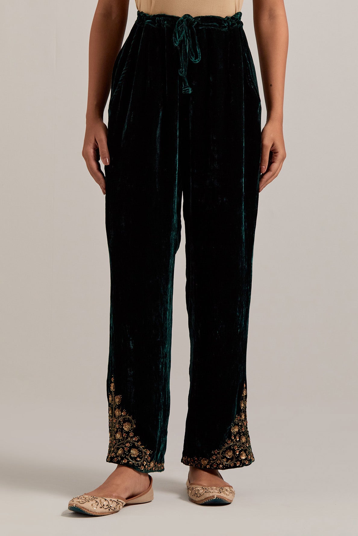 Dark green Silk velvet pants, highlighted with hand embroidered bead, sequins, zardozi and zari boota at bottom hem.