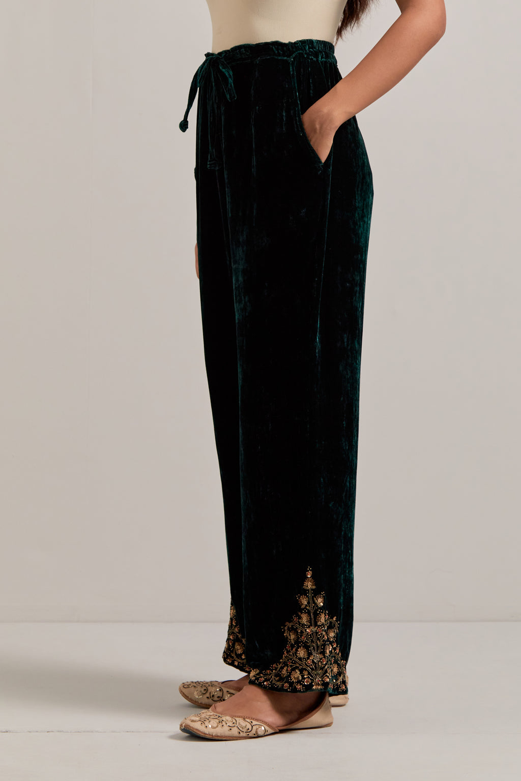 Dark green Silk velvet pants, highlighted with hand embroidered bead, sequins, zardozi and zari boota at bottom hem.