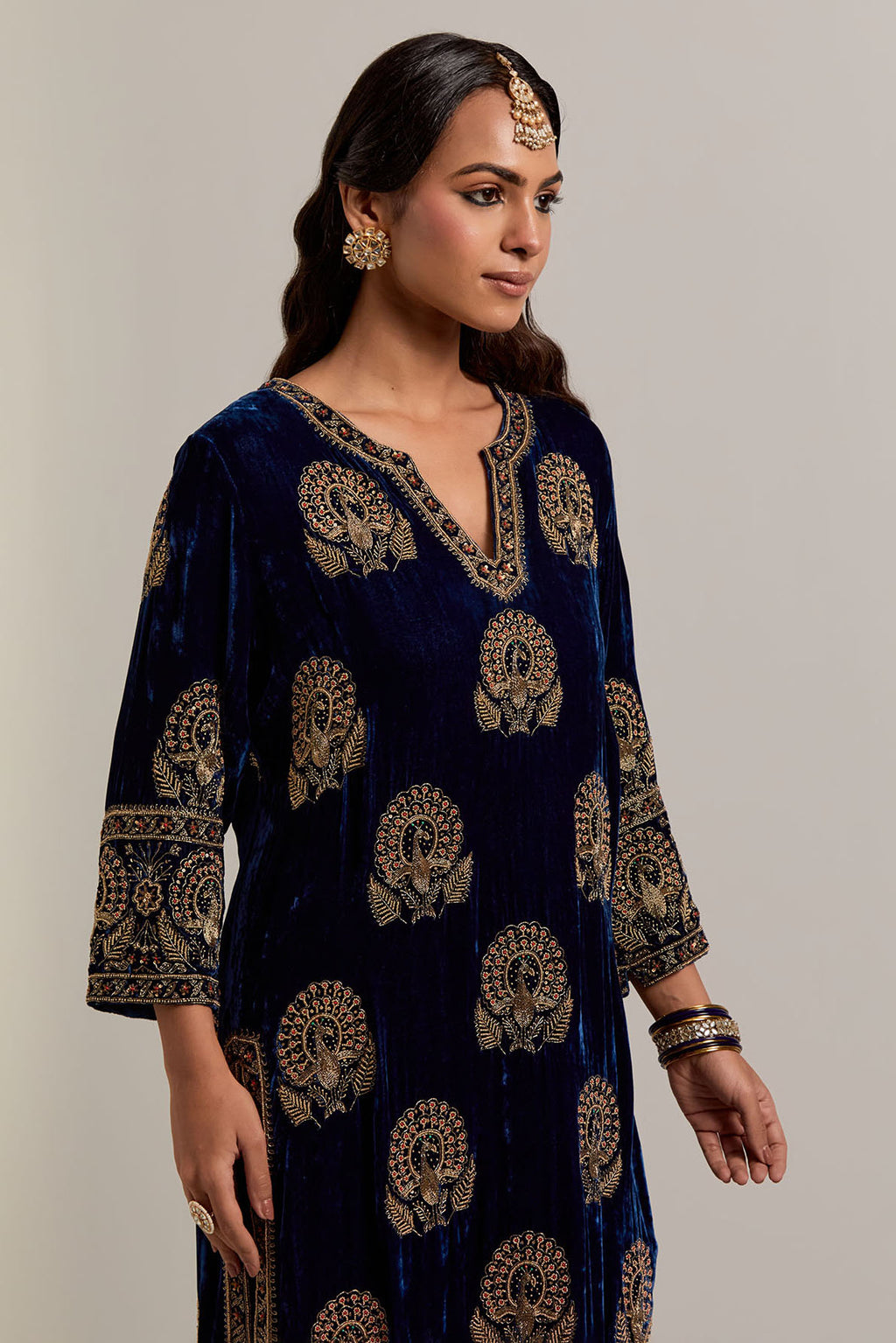 Navy blue silk velvet straight kurta set with sequins, zardozi, zari embroidered peacock boota all-over the kurta, highlighted with contrast bead work.