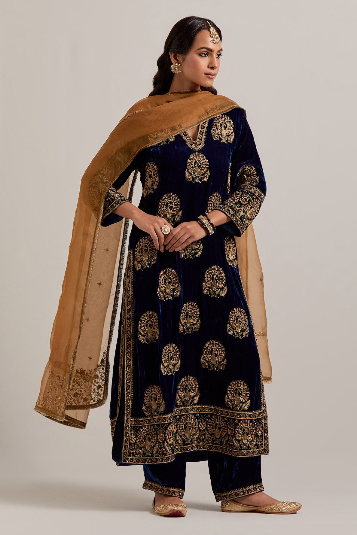 Navy blue silk velvet straight kurta set with sequins, zardozi, zari embroidered peacock boota all-over the kurta, highlighted with contrast bead work.