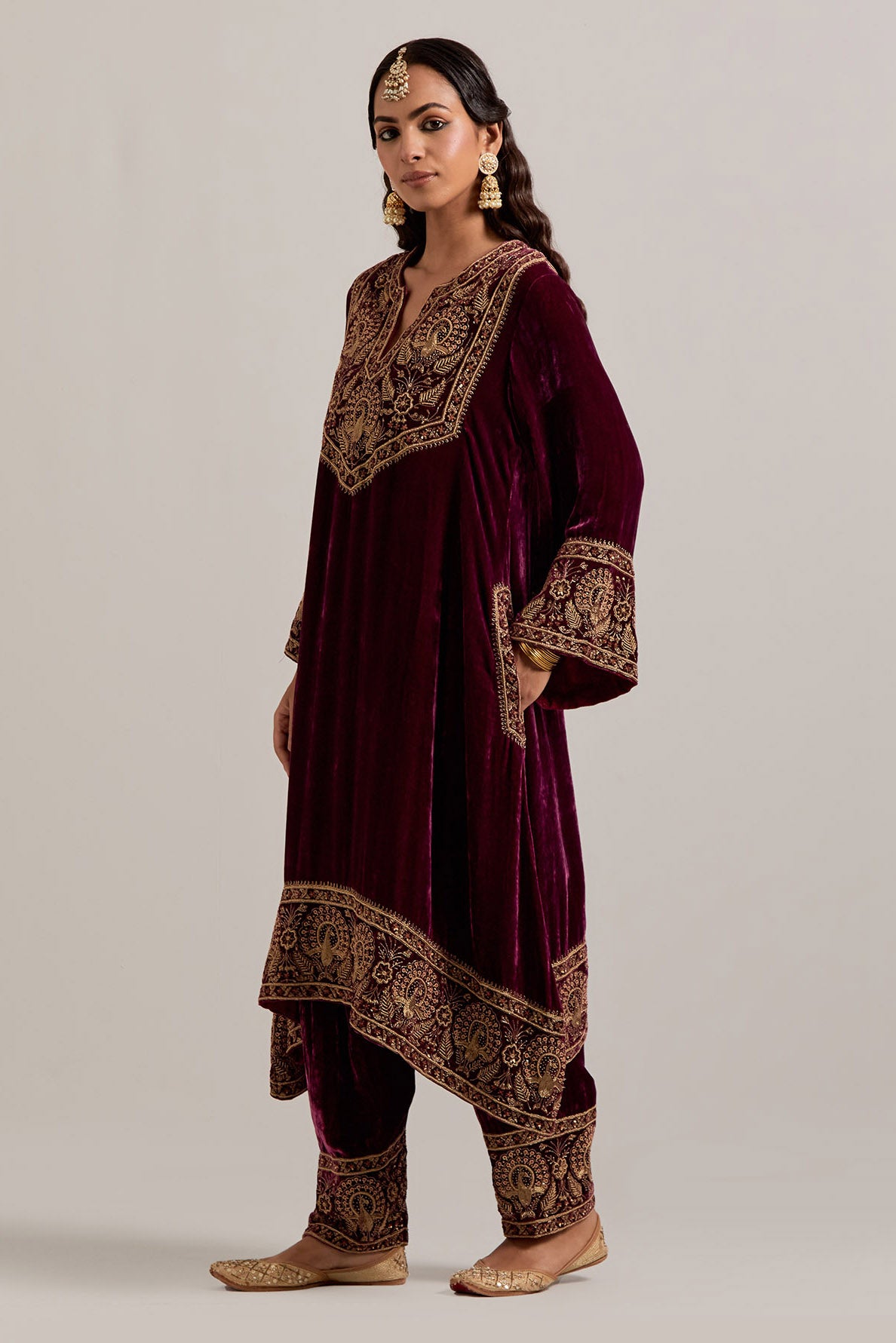 Plum silk velvet short easy fit A-line kurta set with sequins, zardozi, bead and zari embroidered big border at hem, detailed with contrast colored bead.