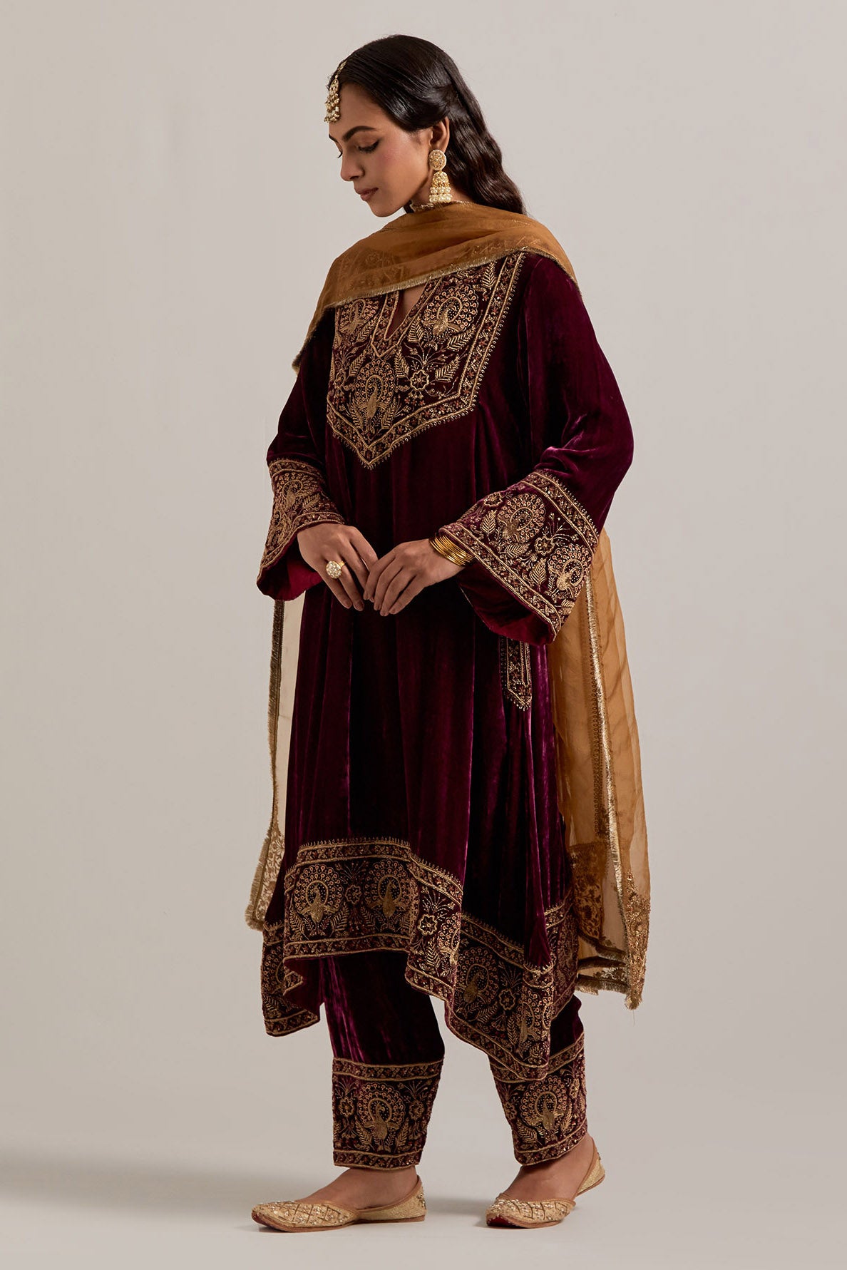 Plum silk velvet short easy fit A-line kurta set with sequins, zardozi, bead and zari embroidered big border at hem, detailed with contrast colored bead.