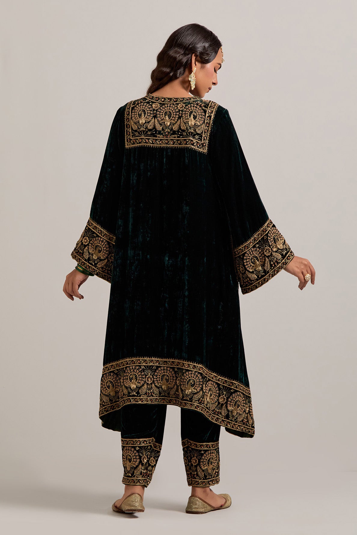 Dark green silk velvet short easy fit A-line kurta set with sequins, zardozi, bead and zari embroidered big border at hem, detailed with contrast colored bead.