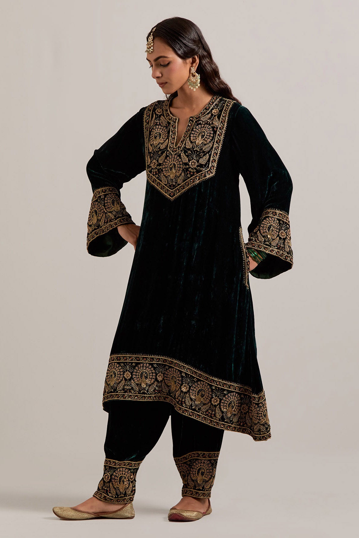 Dark green silk velvet short easy fit A-line kurta set with sequins, zardozi, bead and zari embroidered big border at hem, detailed with contrast colored bead.