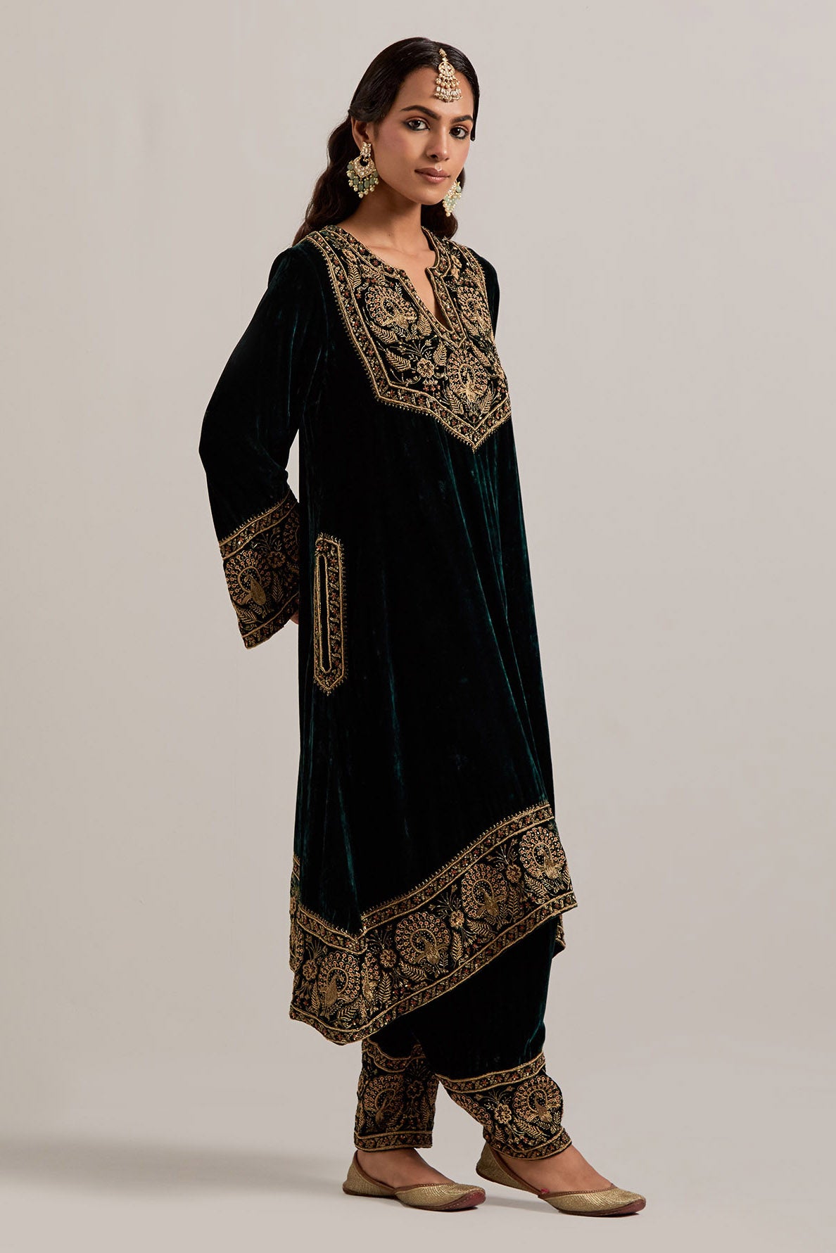 Dark green silk velvet short easy fit A-line kurta set with sequins, zardozi, bead and zari embroidered big border at hem, detailed with contrast colored bead.