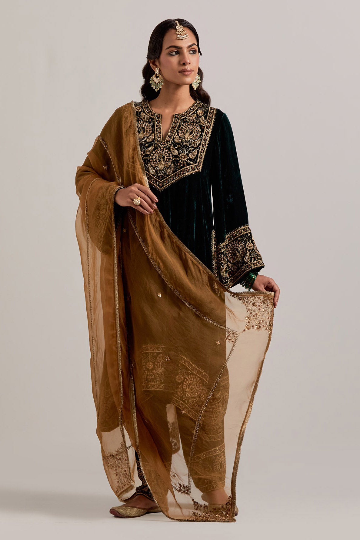 Dark green silk velvet short easy fit A-line kurta set with sequins, zardozi, bead and zari embroidered big border at hem, detailed with contrast colored bead.