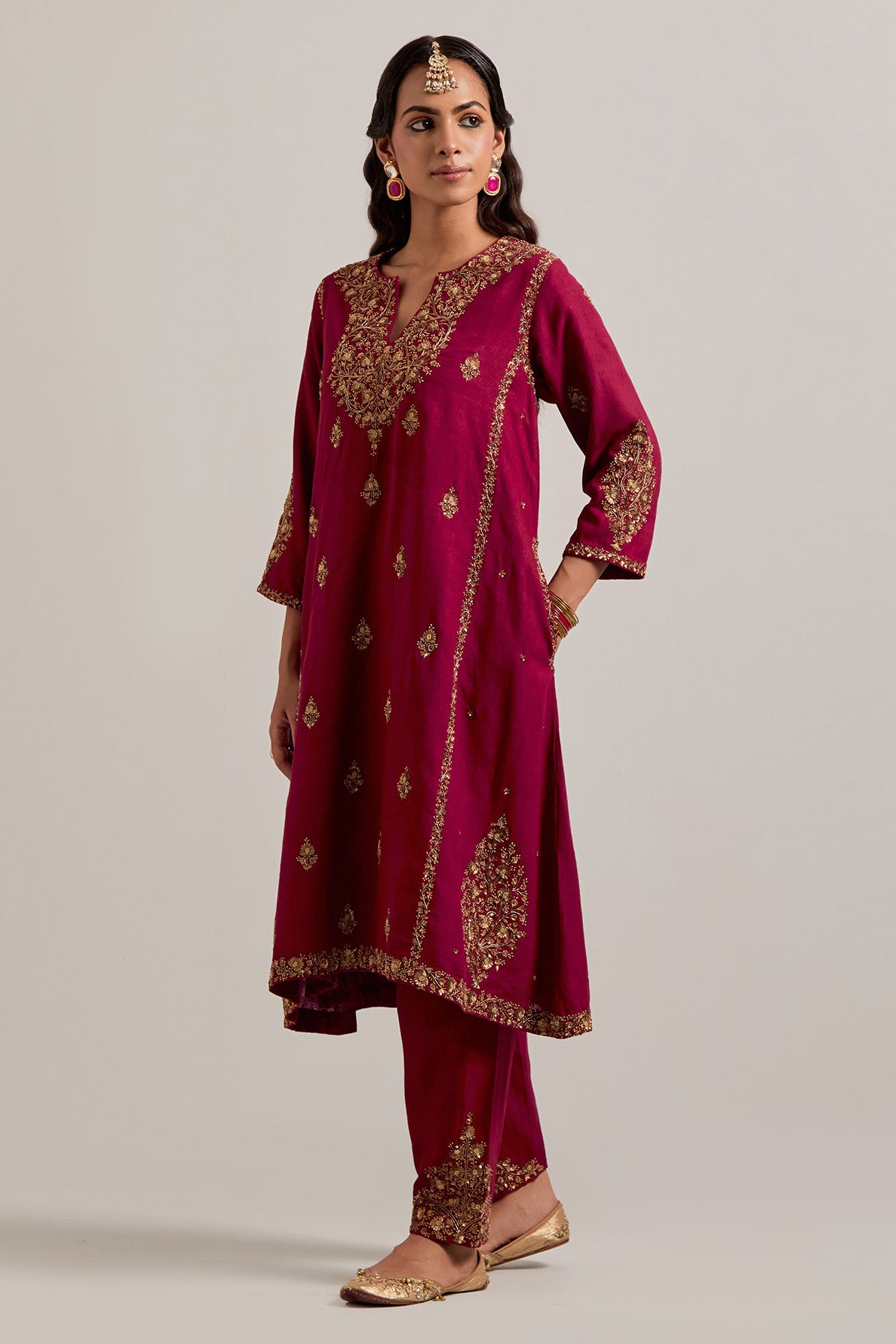 Ruby red easy fit A-line, panelled, short kurta set in Matka silk with all-over hand embroidery at the neck, sleeves and hem.
