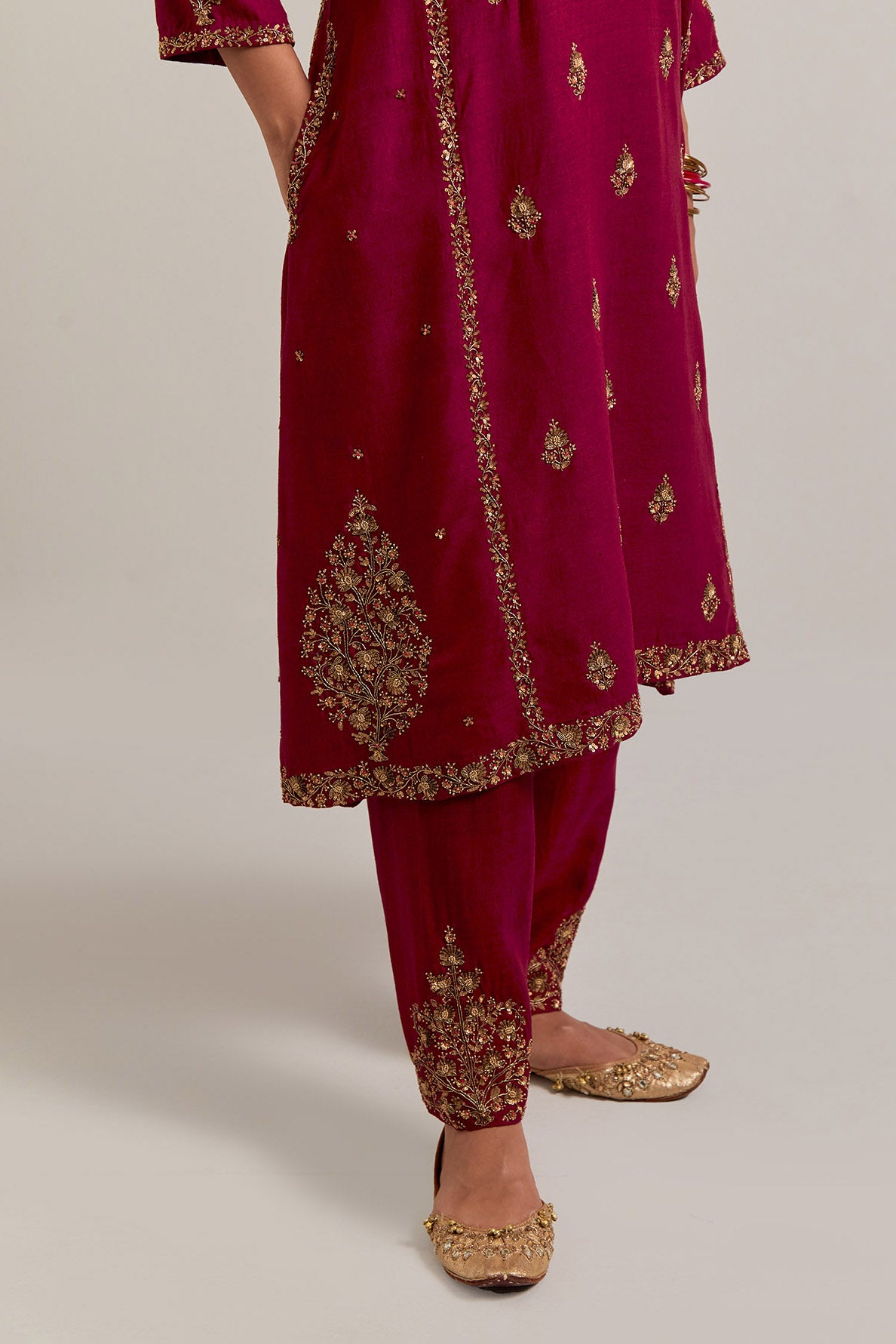 Ruby red easy fit A-line, panelled, short kurta set in Matka silk with all-over hand embroidery at the neck, sleeves and hem.