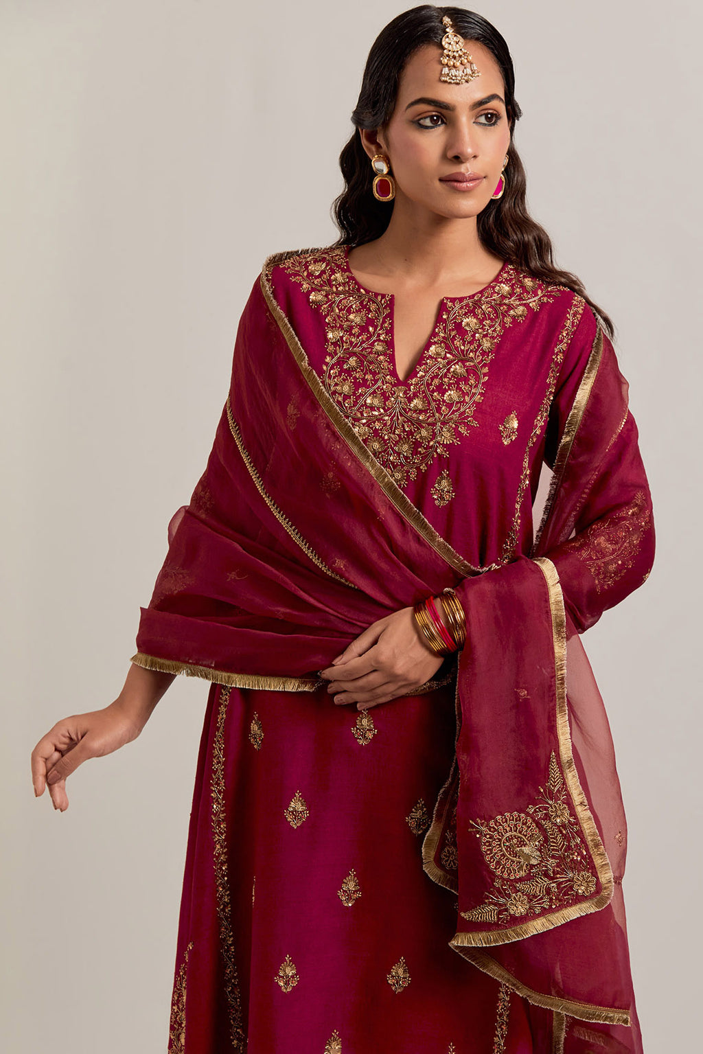 Ruby red easy fit A-line, panelled, short kurta set in Matka silk with all-over hand embroidery at the neck, sleeves and hem.