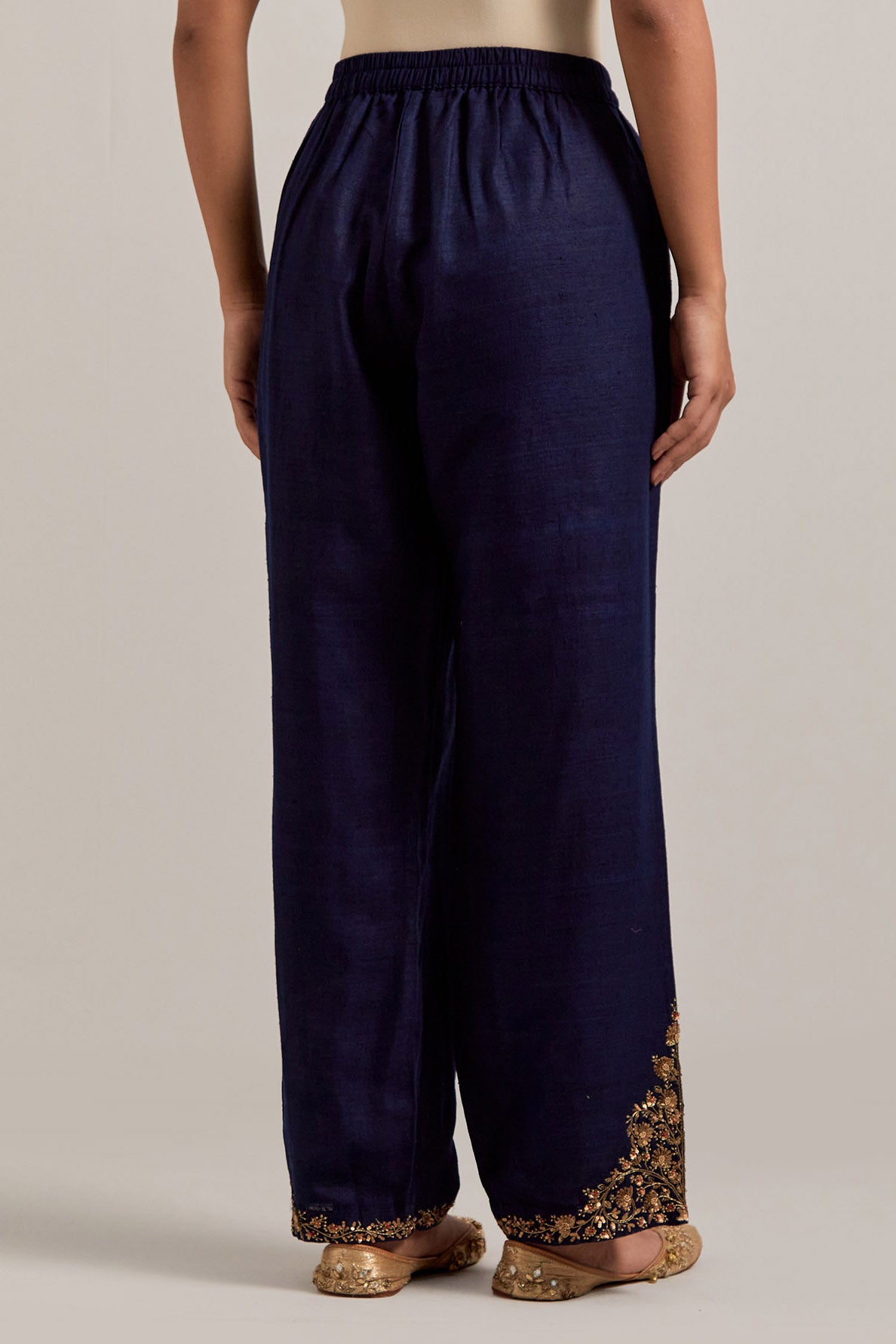 Navy blue Matka silk pants, highlighted with hand embroidered bead, sequins, zardozi and zari boota at bottom hem.