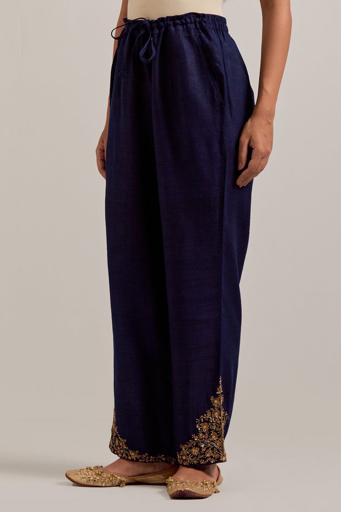 Navy blue Matka silk pants, highlighted with hand embroidered bead, sequins, zardozi and zari boota at bottom hem.