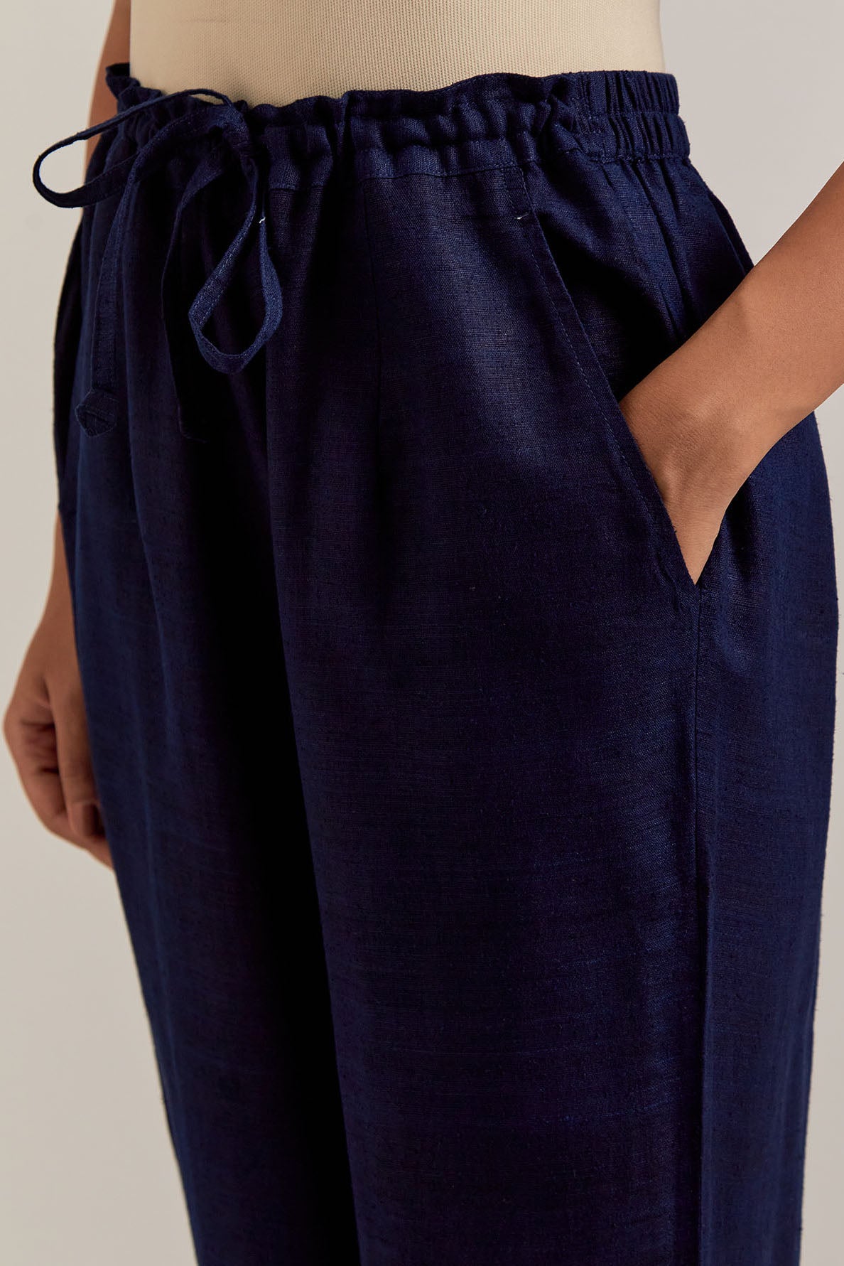 Navy blue Matka silk pants, highlighted with hand embroidered bead, sequins, zardozi and zari boota at bottom hem.