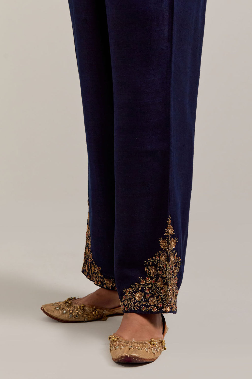 Navy blue Matka silk pants, highlighted with hand embroidered bead, sequins, zardozi and zari boota at bottom hem.