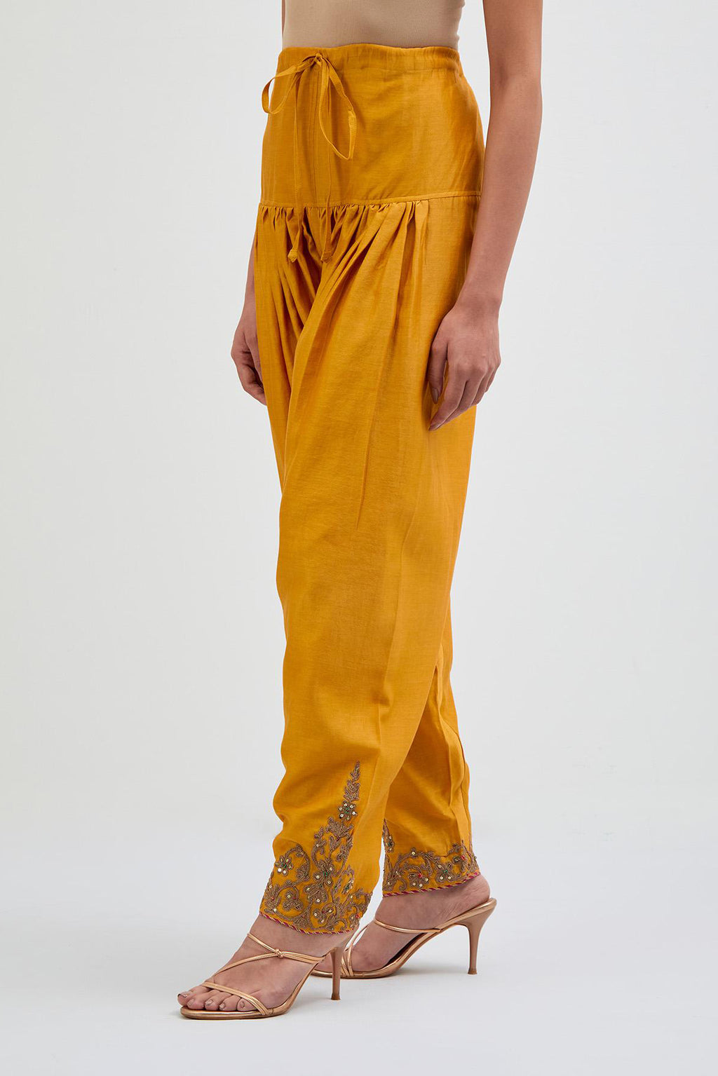 Deep Yellow Silk Chanderi narrow salwar with dori embroidered boota at hem, highlighted with multi colored beads and gold sequins work.