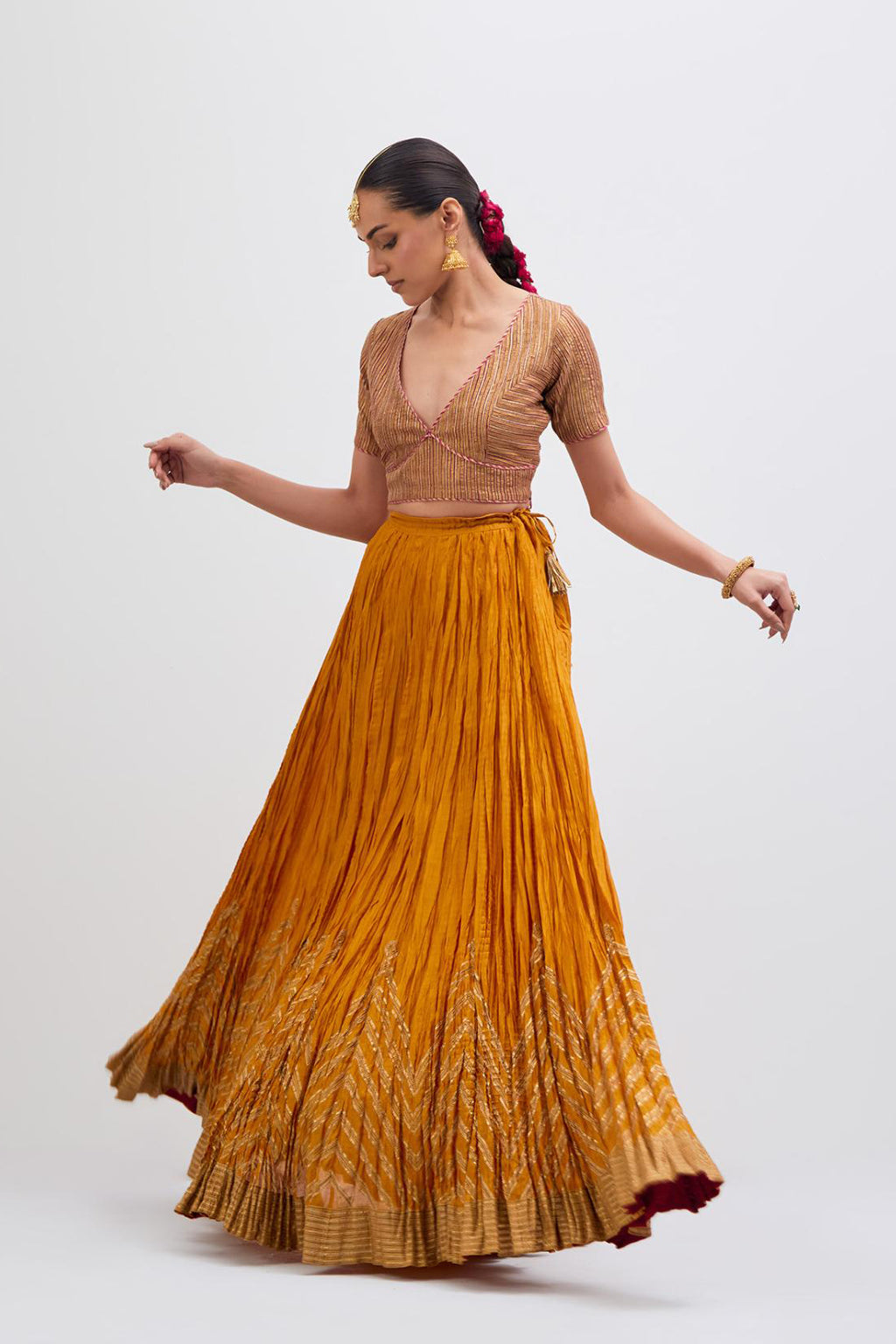 Yellow Silk Chanderi choli set with all-over gold gota work. It has a deep V neckline in the front, short sleeves and side zip.