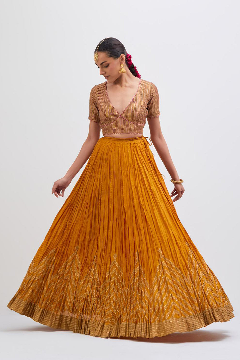 Yellow Silk Chanderi choli set with all-over gold gota work. It has a deep V neckline in the front, short sleeves and side zip.