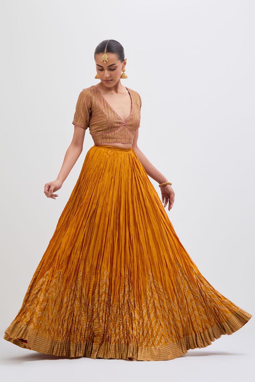 Yellow Silk Chanderi choli set with all-over gold gota work. It has a deep V neckline in the front, short sleeves and side zip.