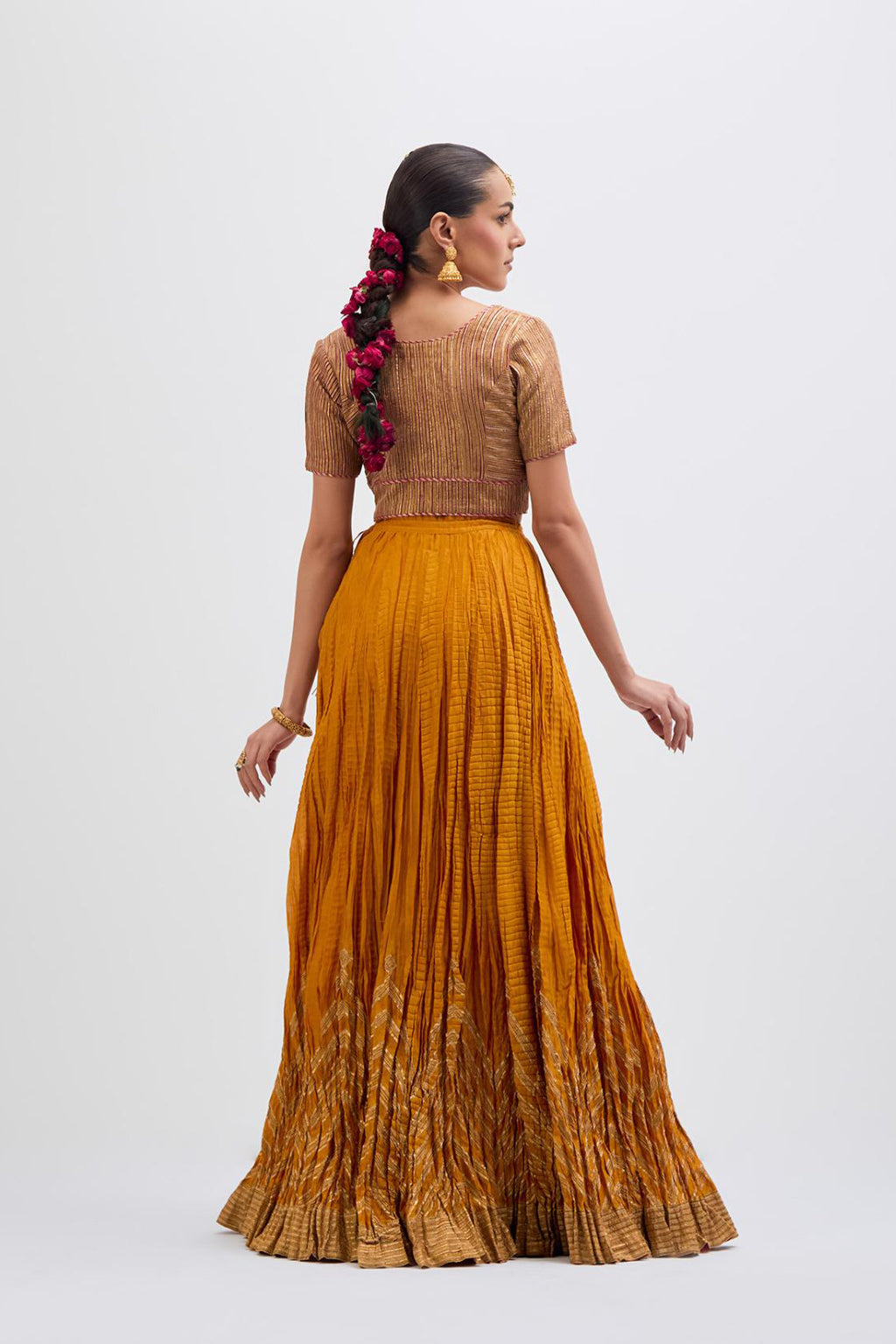 Yellow Silk Chanderi choli set with all-over gold gota work. It has a deep V neckline in the front, short sleeves and side zip.