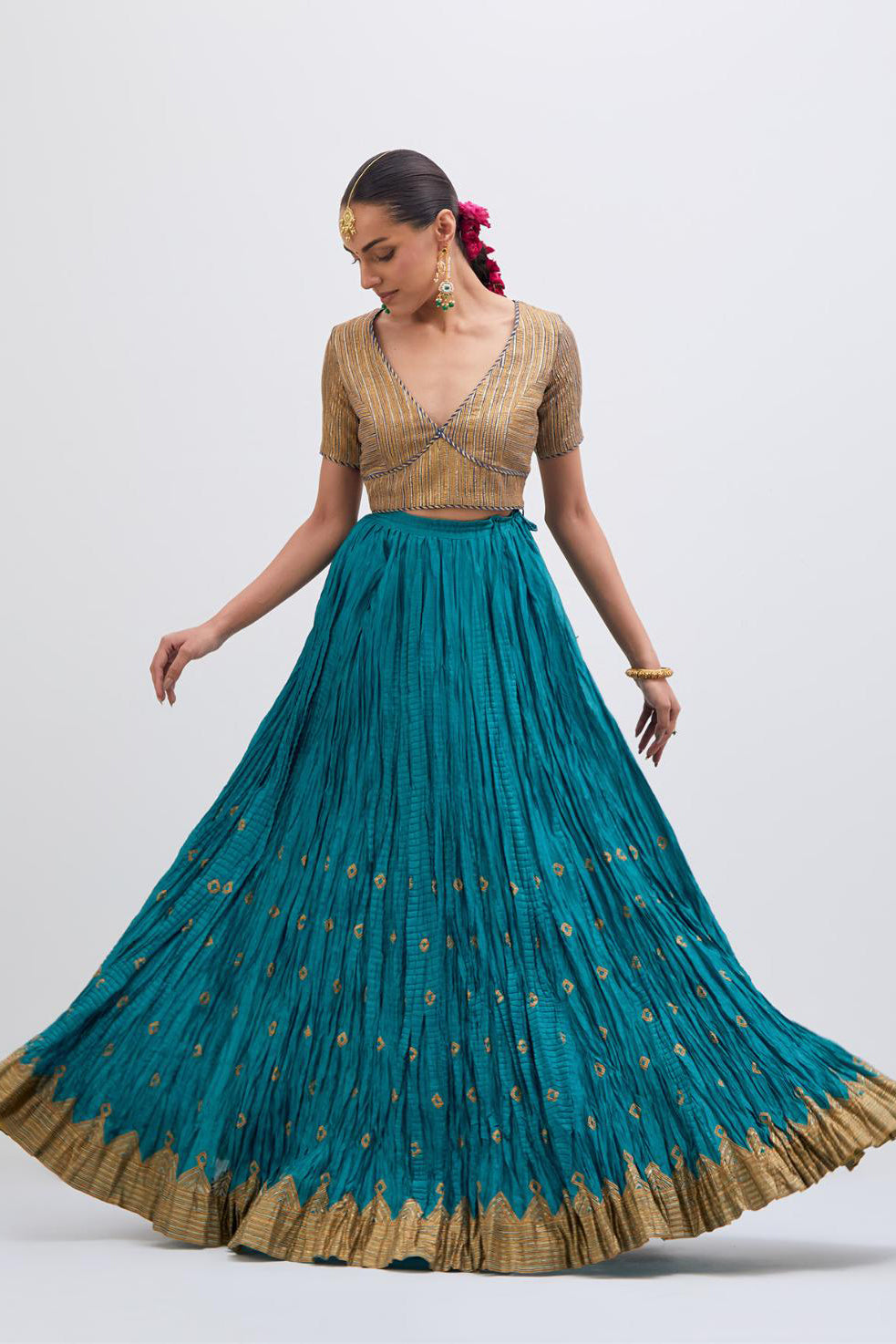 Blue Silk Chanderi choli set with all-over gold gota work. It has a deep V neckline in the front, short sleeves and side zip.