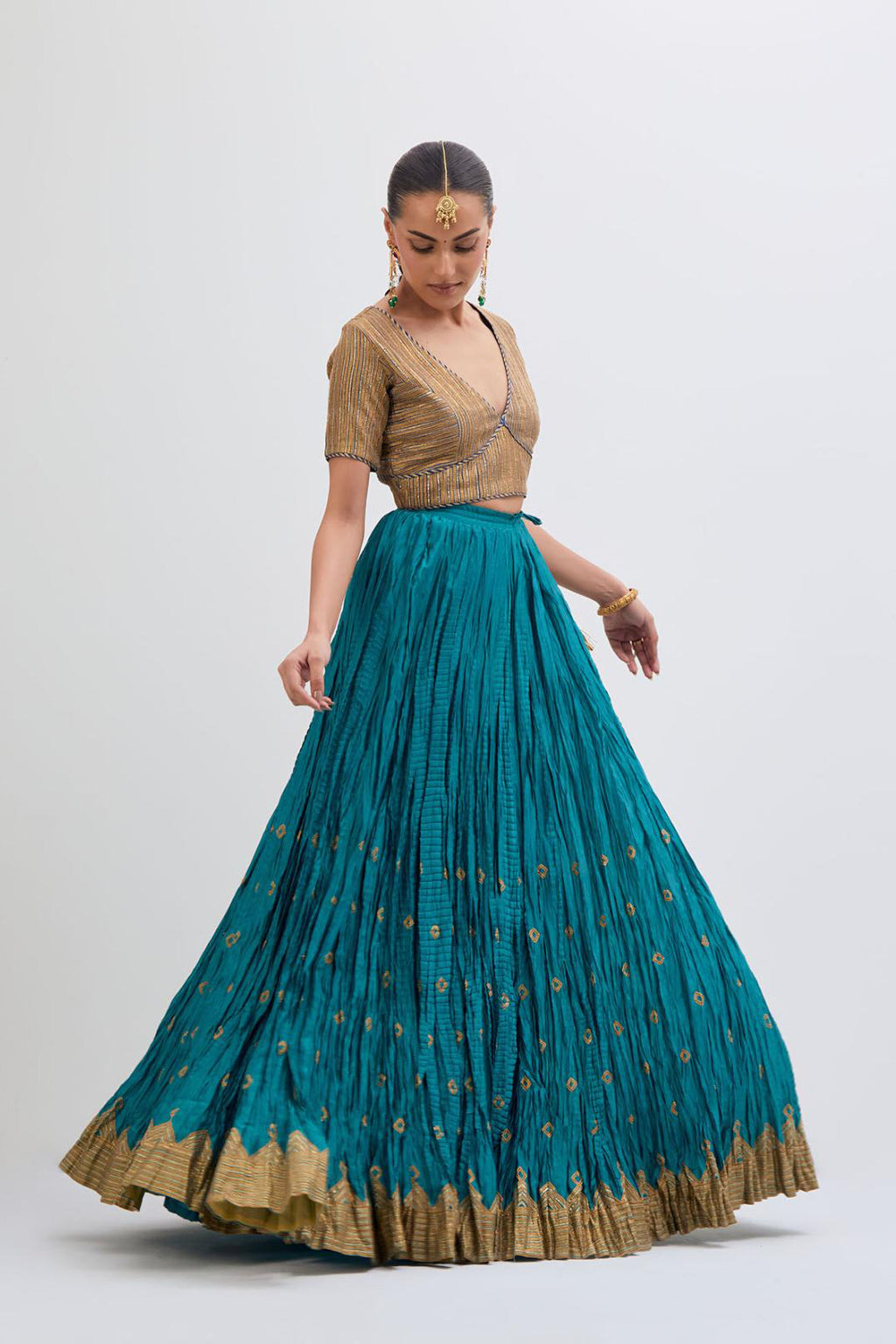 Blue Silk Chanderi choli set with all-over gold gota work. It has a deep V neckline in the front, short sleeves and side zip.