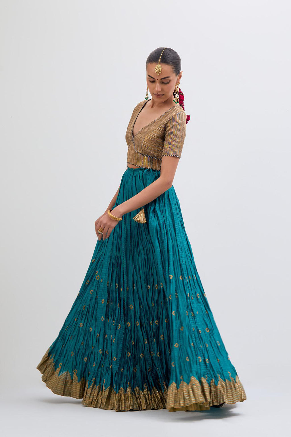 Blue Silk Chanderi choli set with all-over gold gota work. It has a deep V neckline in the front, short sleeves and side zip.
