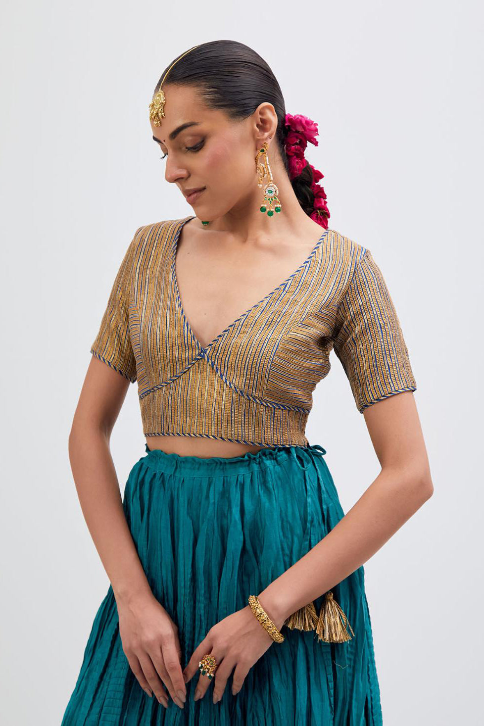 Blue Silk Chanderi choli set with all-over gold gota work. It has a deep V neckline in the front, short sleeves and side zip.