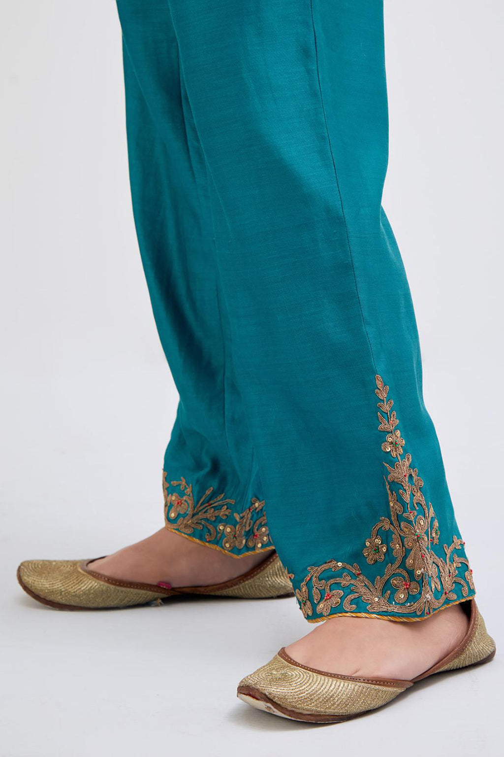 Teal Silk Chanderi pants with dull gold dori embroidery at hem, highlighted with multi colored beads and gold sequins work.