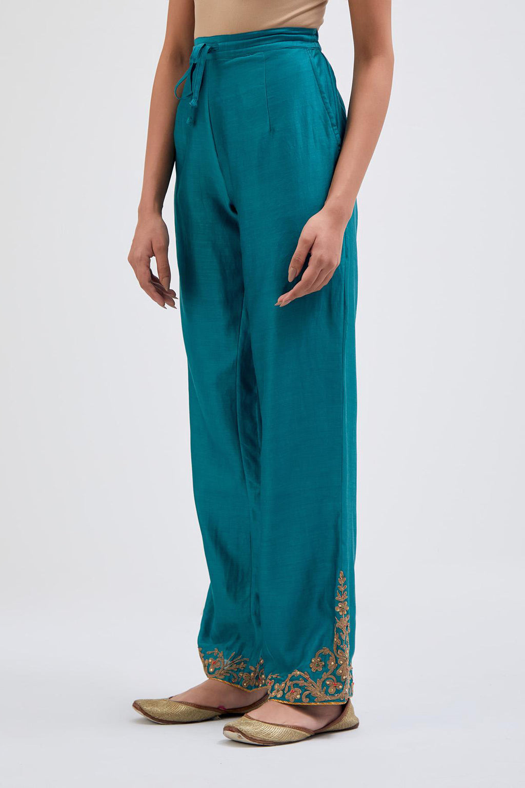 Teal Silk Chanderi pants with dull gold dori embroidery at hem, highlighted with multi colored beads and gold sequins work.