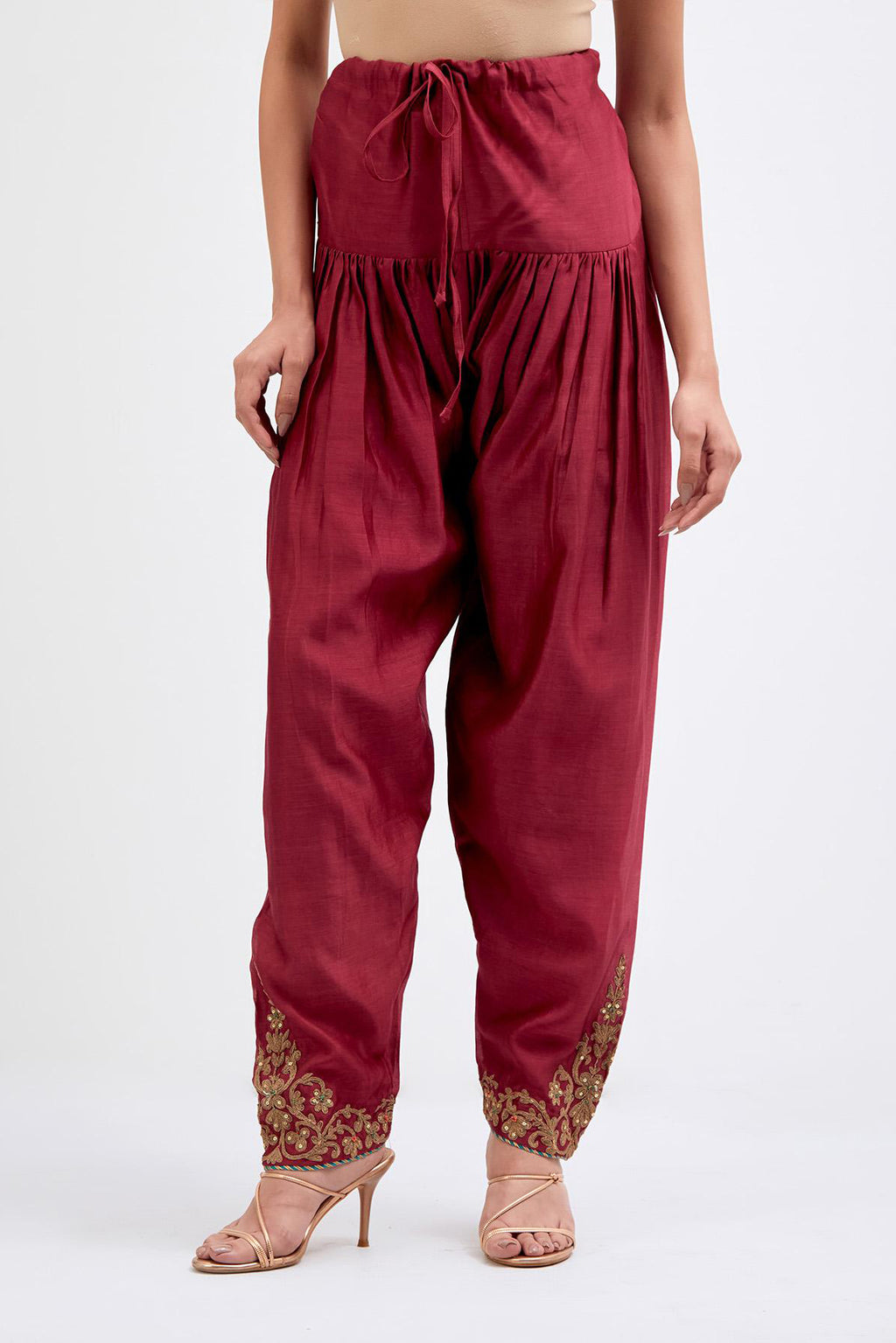Red Silk Chanderi narrow salwar with dori embroidered boota at hem, highlighted with multi colored beads and gold sequins work.