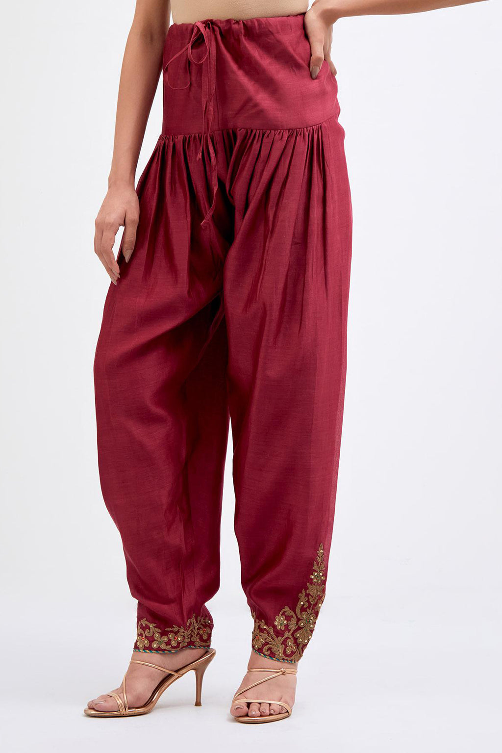 Red Silk Chanderi narrow salwar with dori embroidered boota at hem, highlighted with multi colored beads and gold sequins work.