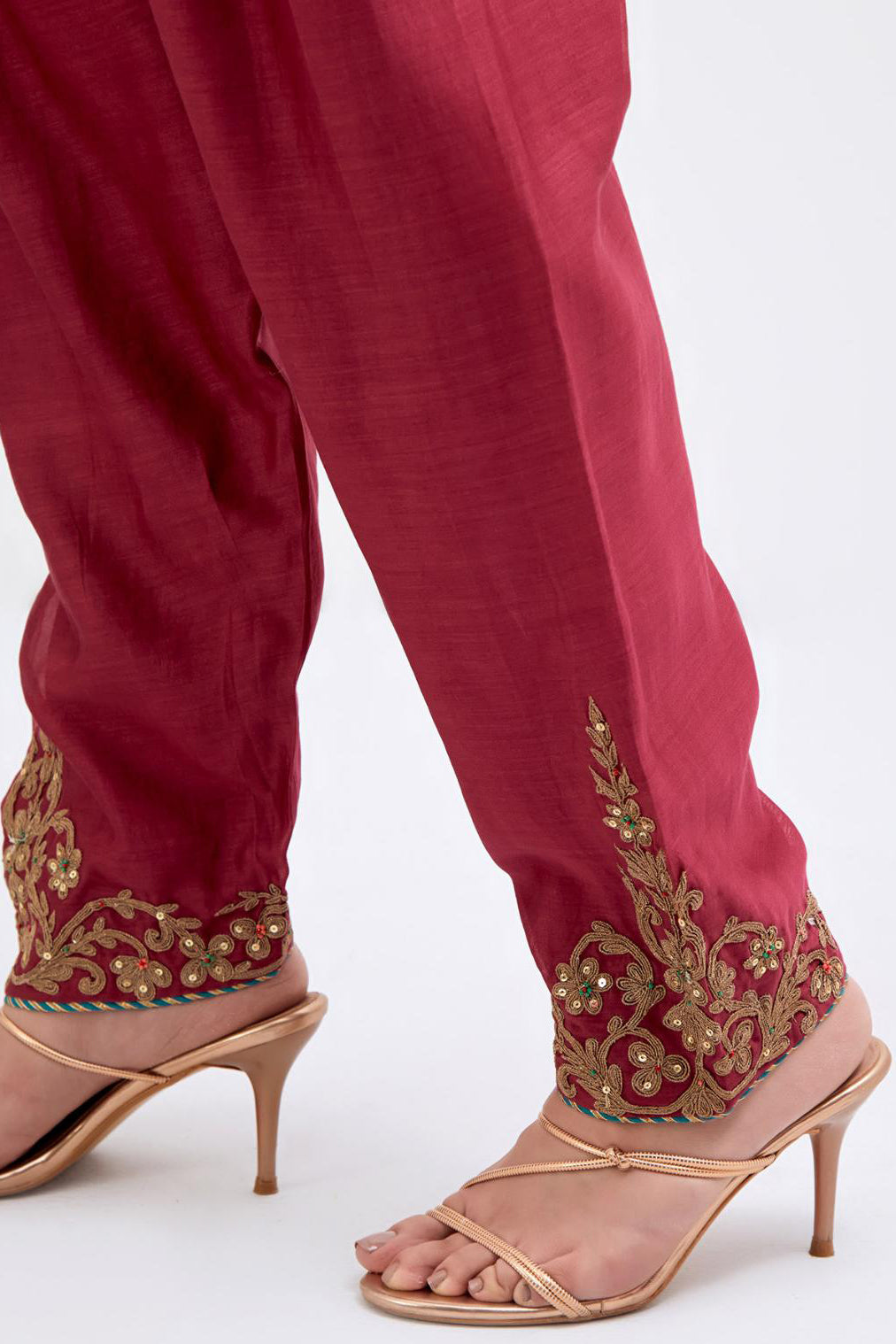 Red Silk Chanderi narrow salwar with dori embroidered boota at hem, highlighted with multi colored beads and gold sequins work.
