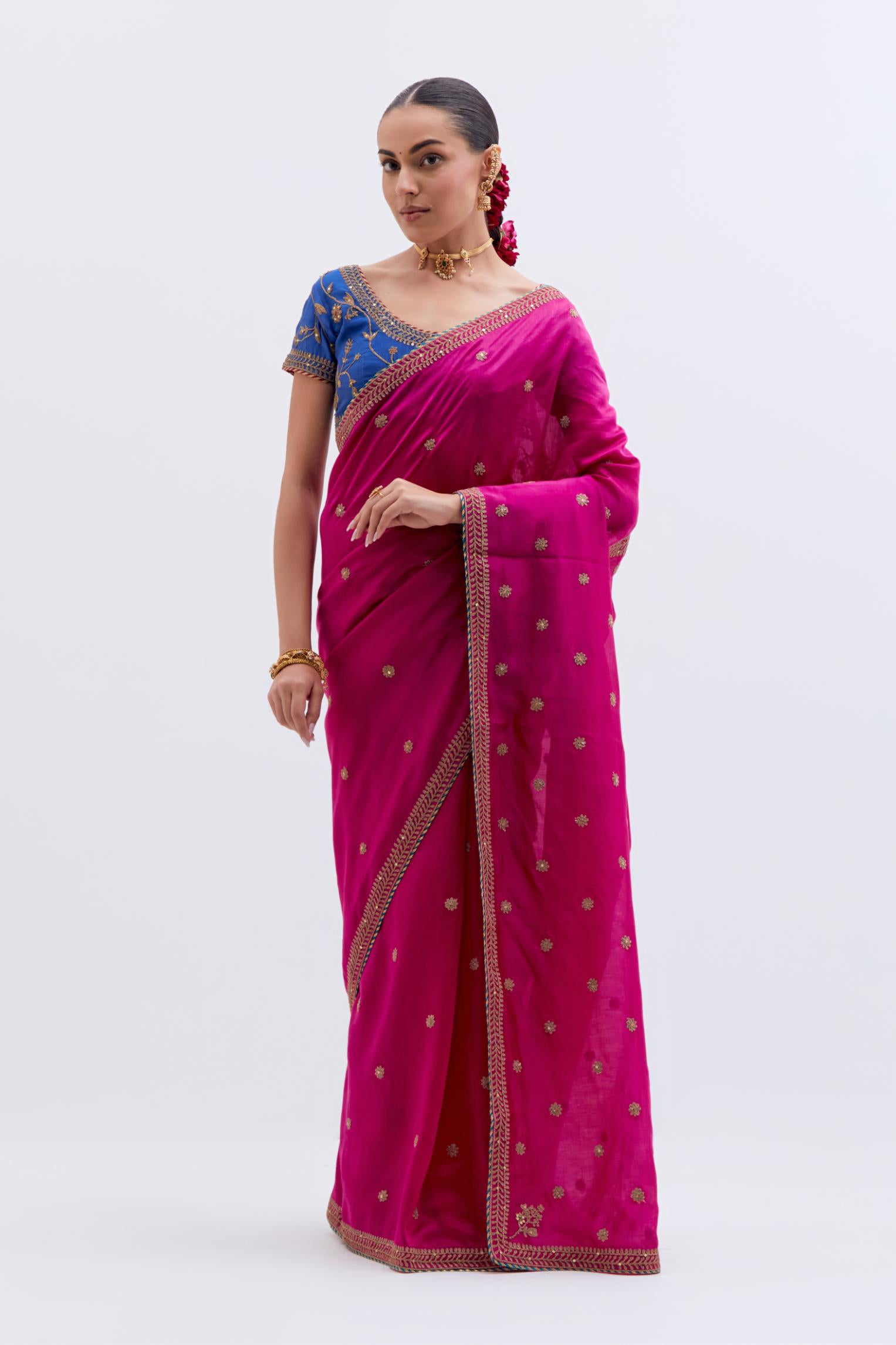 Fuchsia Silk Chanderi saree with all-over small floral dull gold dori booti embroidery, highlighted with multi colored beads and gold sequins work, paired with Chelsea Blue Silk Chanderi blouse with all-over dull gold dori embroidery.