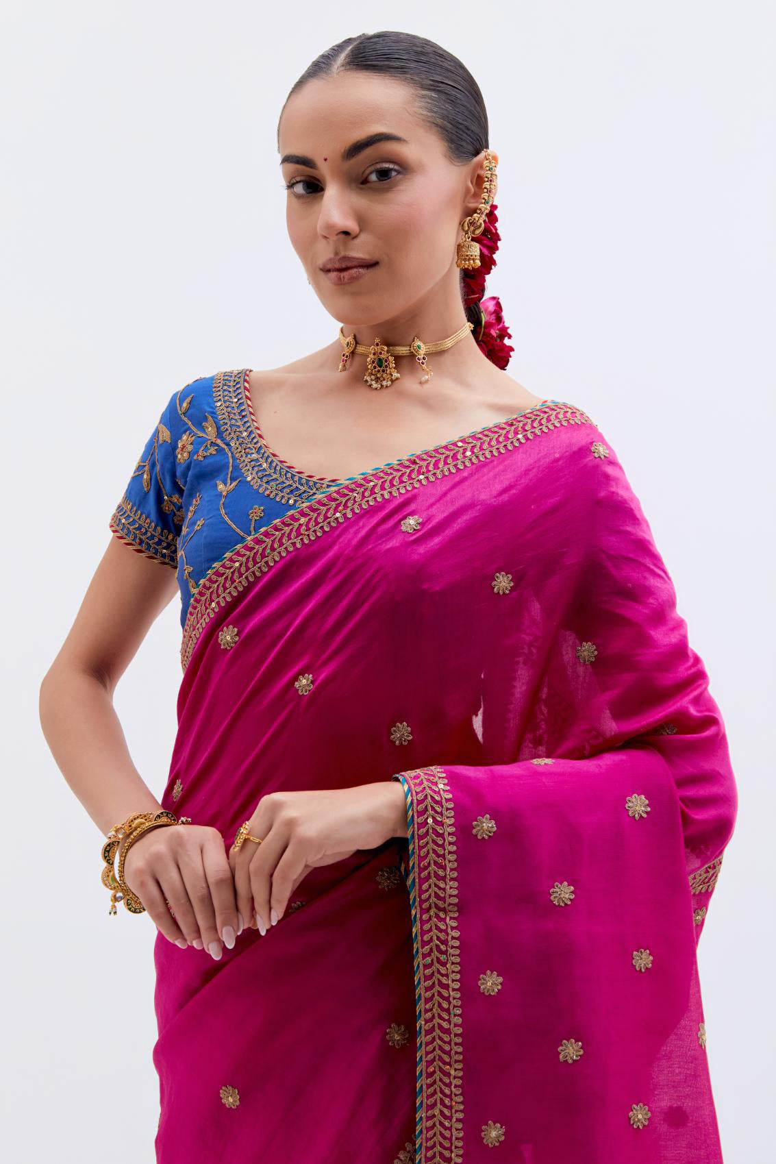 Fuchsia Silk Chanderi saree with all-over small floral dull gold dori booti embroidery, highlighted with multi colored beads and gold sequins work, paired with Chelsea Blue Silk Chanderi blouse with all-over dull gold dori embroidery.