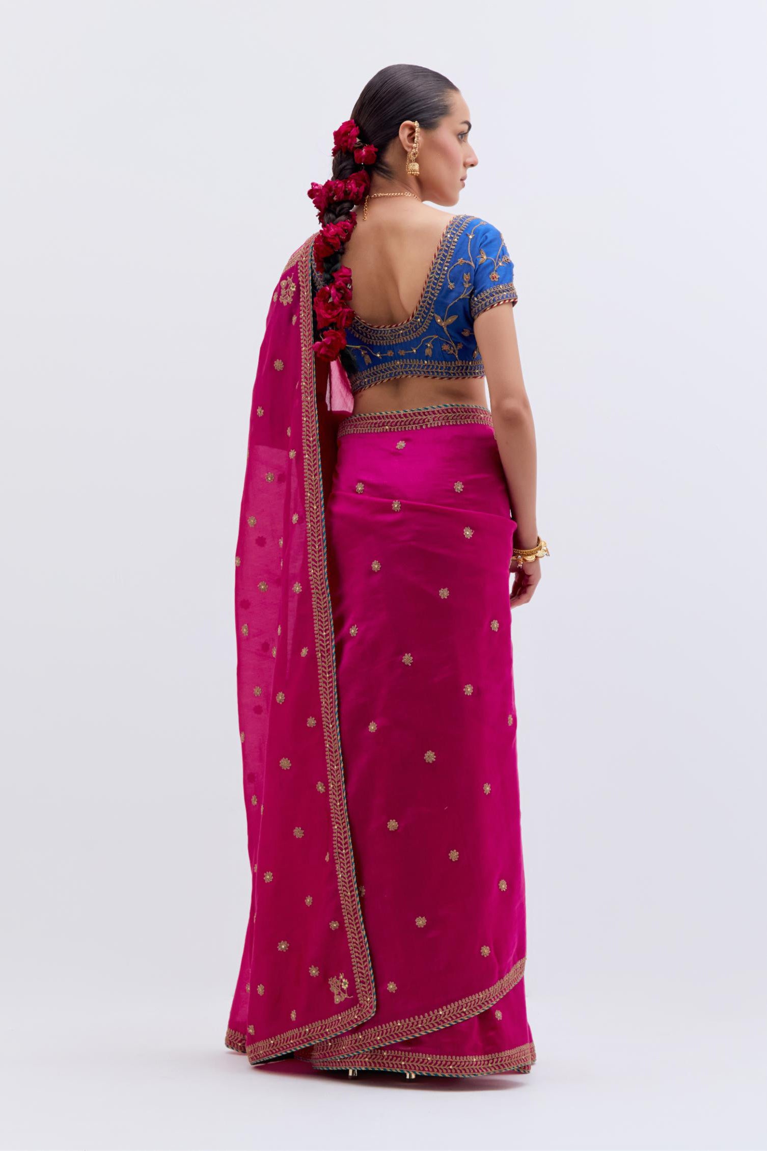 Fuchsia Silk Chanderi saree with all-over small floral dull gold dori booti embroidery, highlighted with multi colored beads and gold sequins work, paired with Chelsea Blue Silk Chanderi blouse with all-over dull gold dori embroidery.