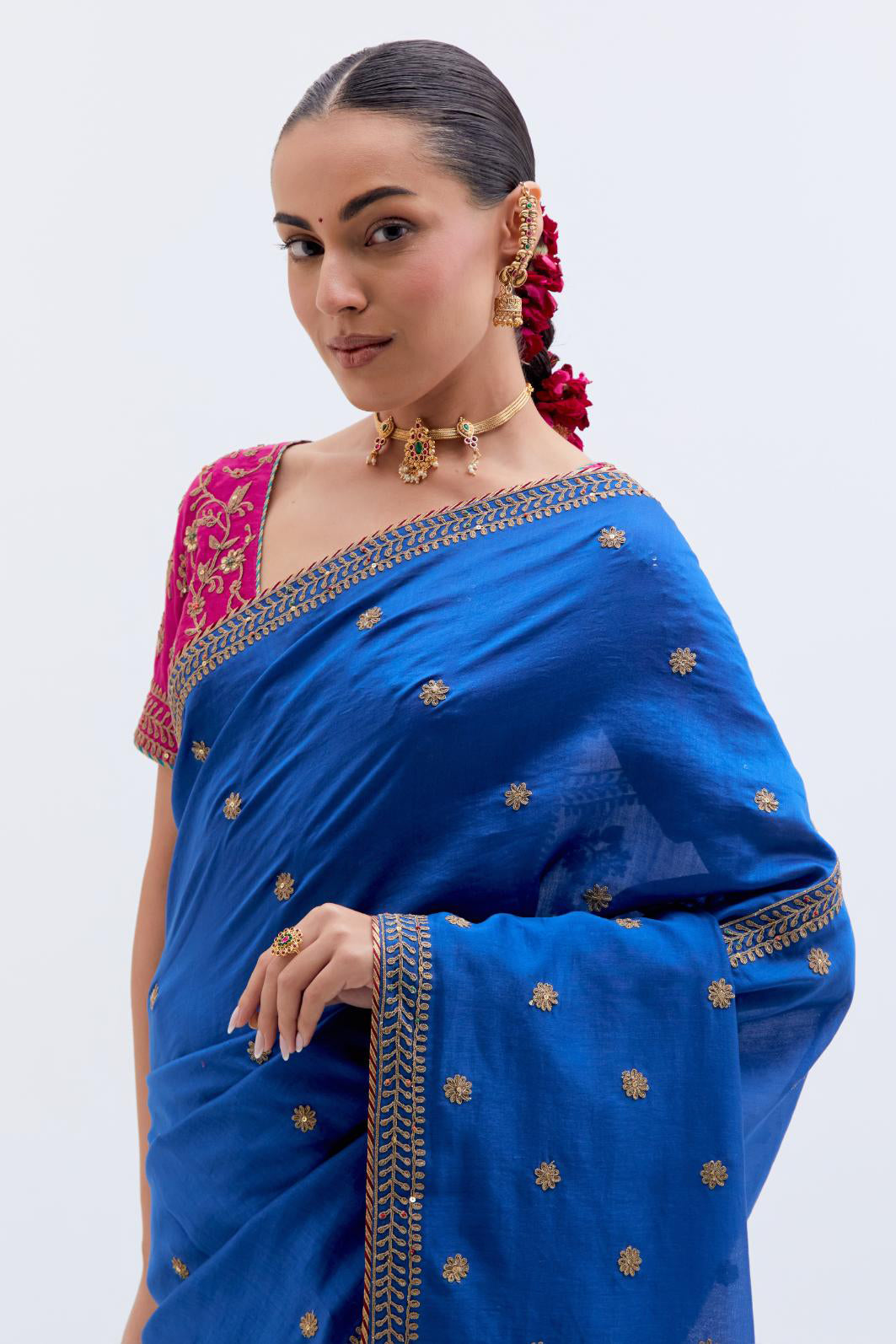 Chelsea Blue Silk Chanderi saree with all-over small floral dull gold dori booti embroidery, highlighted with multi colored beads and gold sequins work, paired with Fuchsia Silk Chanderi blouse with all-over dull gold dori embroidery.