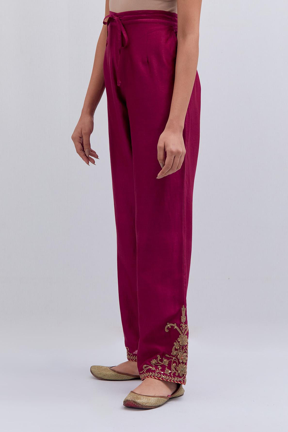 Deep fuchsia Silk Chanderi pants with dull gold dori embroidery at hem, highlighted with multi colored beads and gold sequins work.