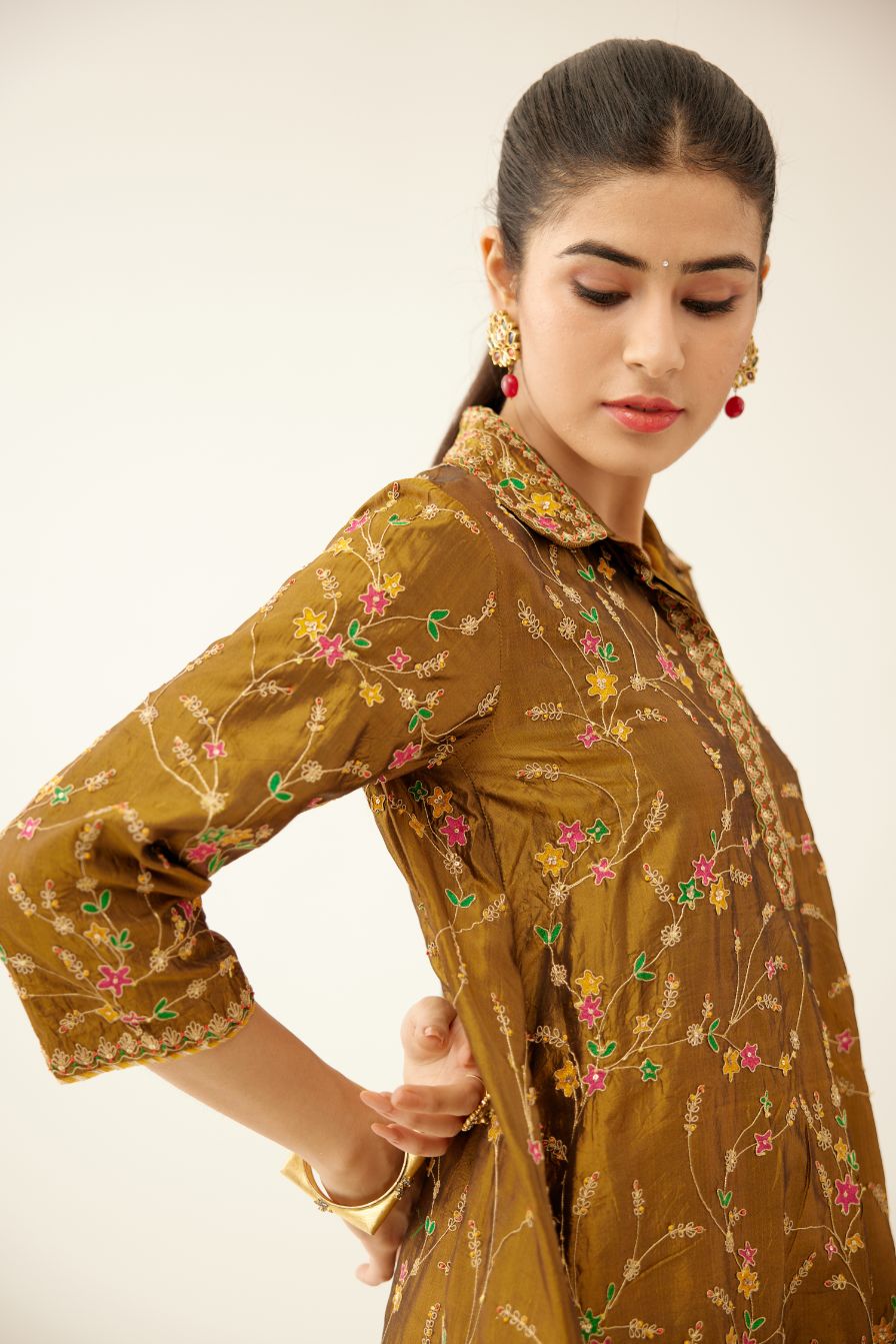 Golden olive A-line short silk kurta set with all over embroidery, highlighted with sequins and bead work, paired with golden olive silk straight pants with dori and silk thread embroidery.