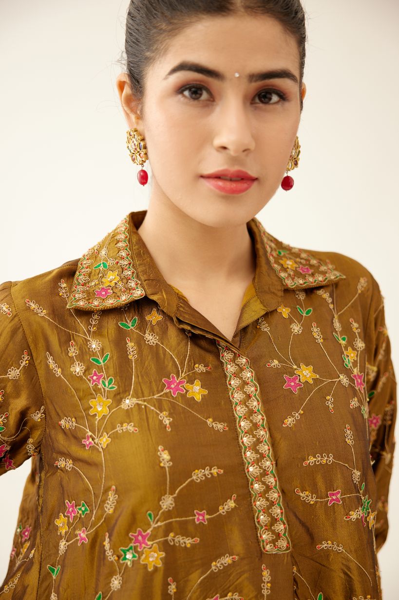 Golden olive A-line short silk kurta set with all over embroidery, highlighted with sequins and bead work, paired with golden olive silk straight pants with dori and silk thread embroidery.