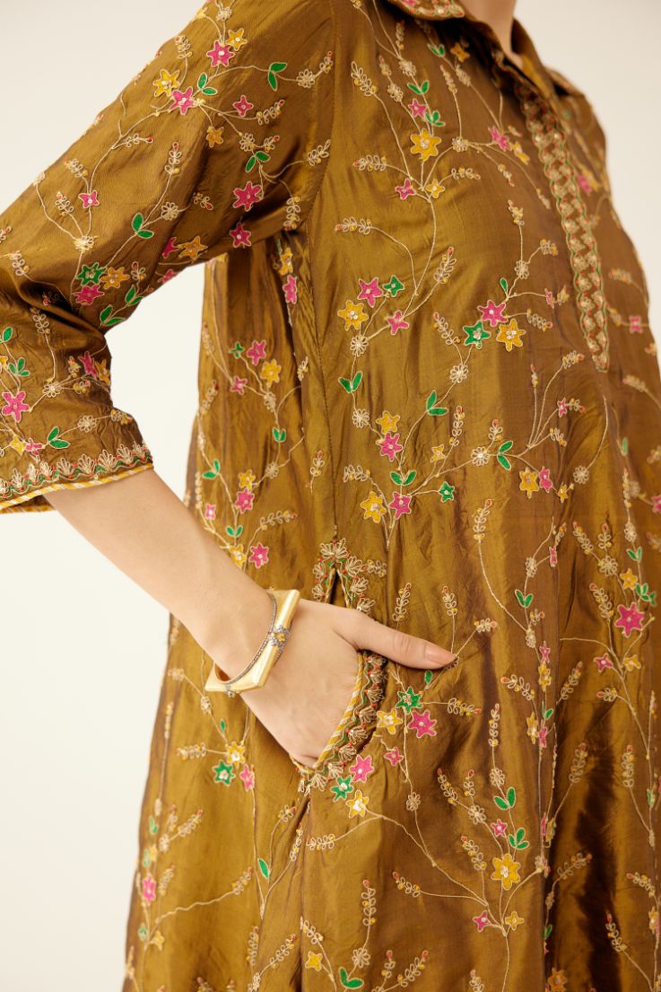 Golden olive A-line short silk kurta set with all over embroidery, highlighted with sequins and bead work, paired with golden olive silk straight pants with dori and silk thread embroidery.