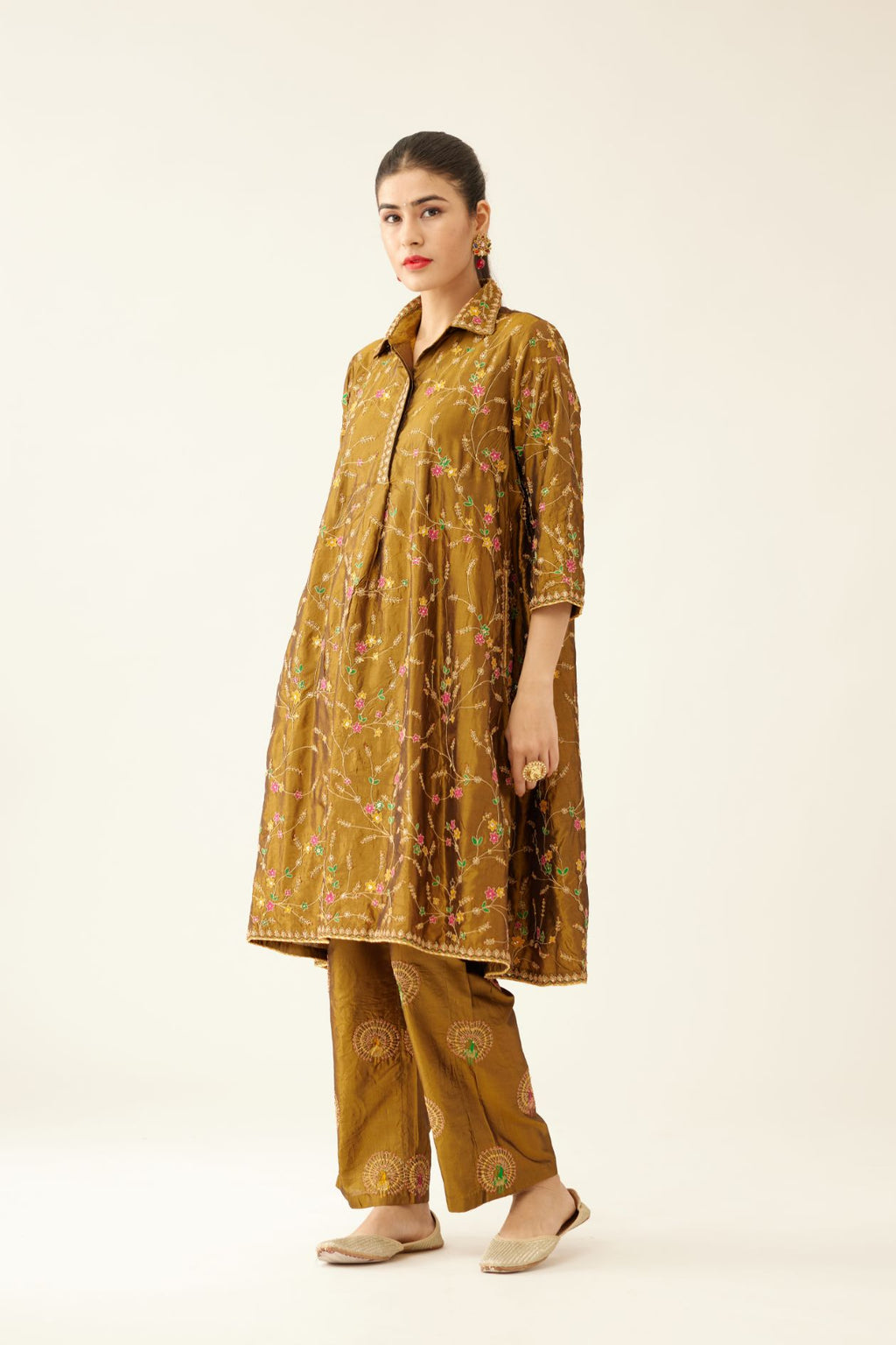 Golden olive A-line short silk kurta set with all over embroidery, highlighted with sequins and bead work, paired with golden olive silk straight pants with dori and silk thread embroidery.