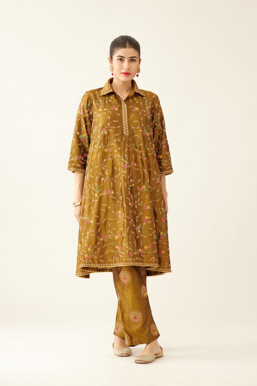 Golden olive A-line short silk kurta set with all over embroidery, highlighted with sequins and bead work, paired with golden olive silk straight pants with dori and silk thread embroidery.