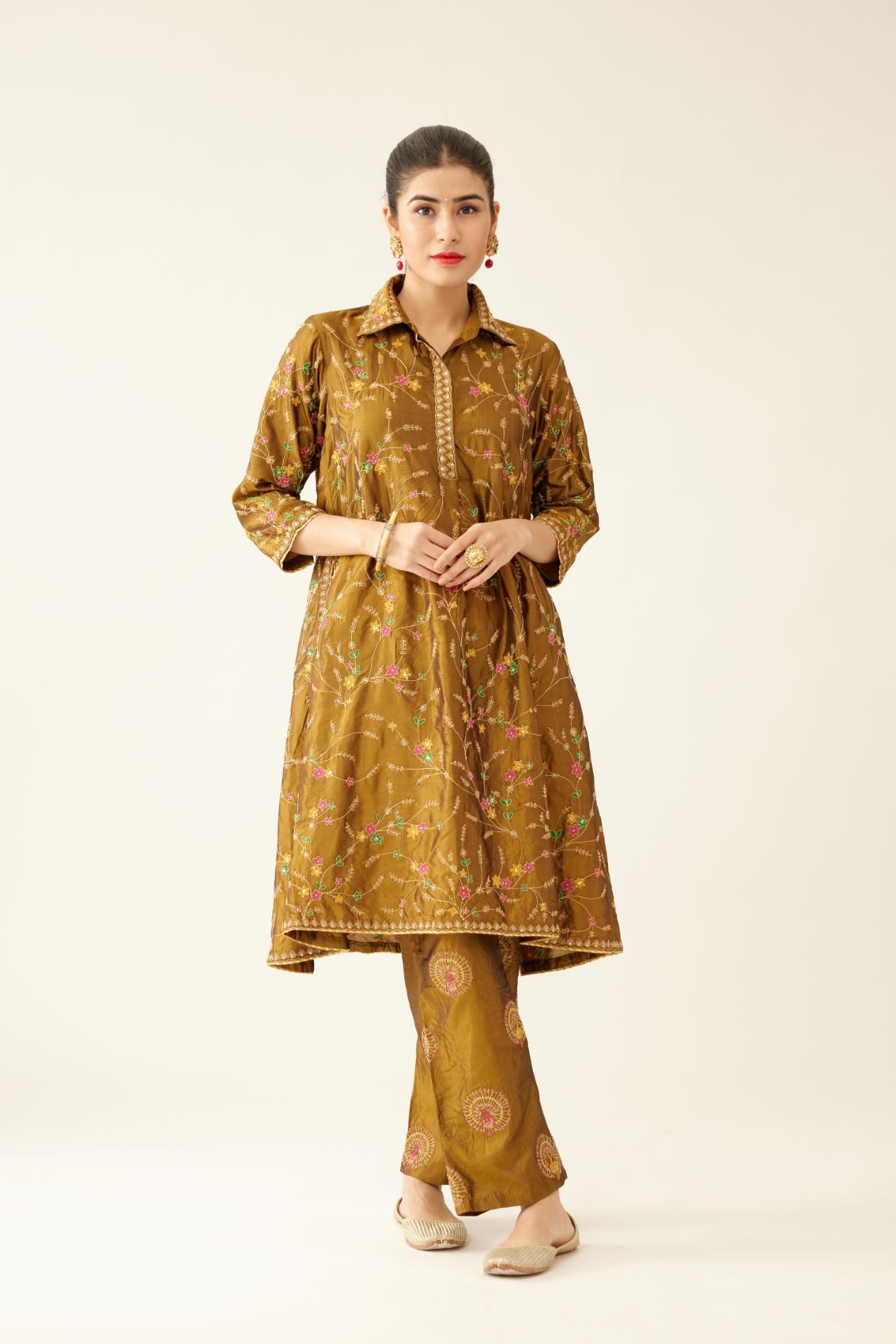 Golden olive A-line short silk kurta set with all over embroidery, highlighted with sequins and bead work, paired with golden olive silk straight pants with dori and silk thread embroidery.
