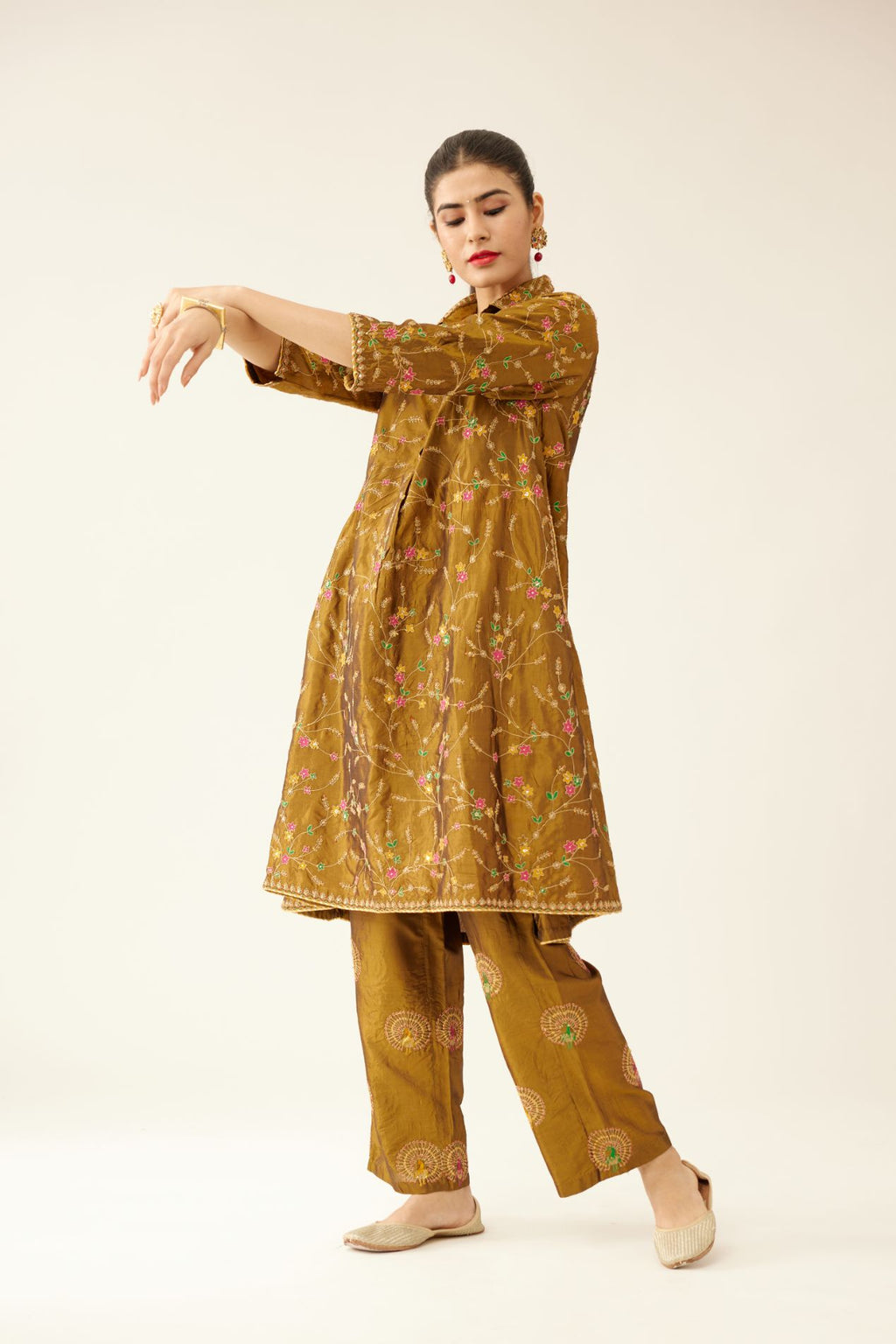 Golden olive A-line short silk kurta set with all over embroidery, highlighted with sequins and bead work, paired with golden olive silk straight pants with dori and silk thread embroidery.