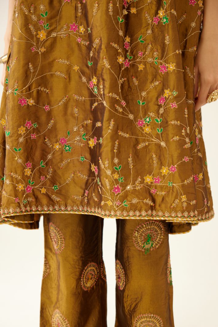 Golden olive A-line short silk kurta set with all over embroidery, highlighted with sequins and bead work, paired with golden olive silk straight pants with dori and silk thread embroidery.