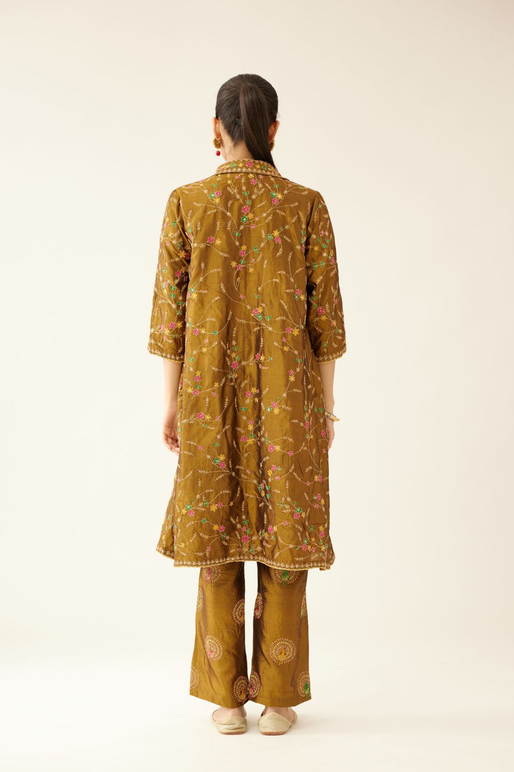 Golden olive A-line short silk kurta set with all over embroidery, highlighted with sequins and bead work, paired with golden olive silk straight pants with dori and silk thread embroidery.