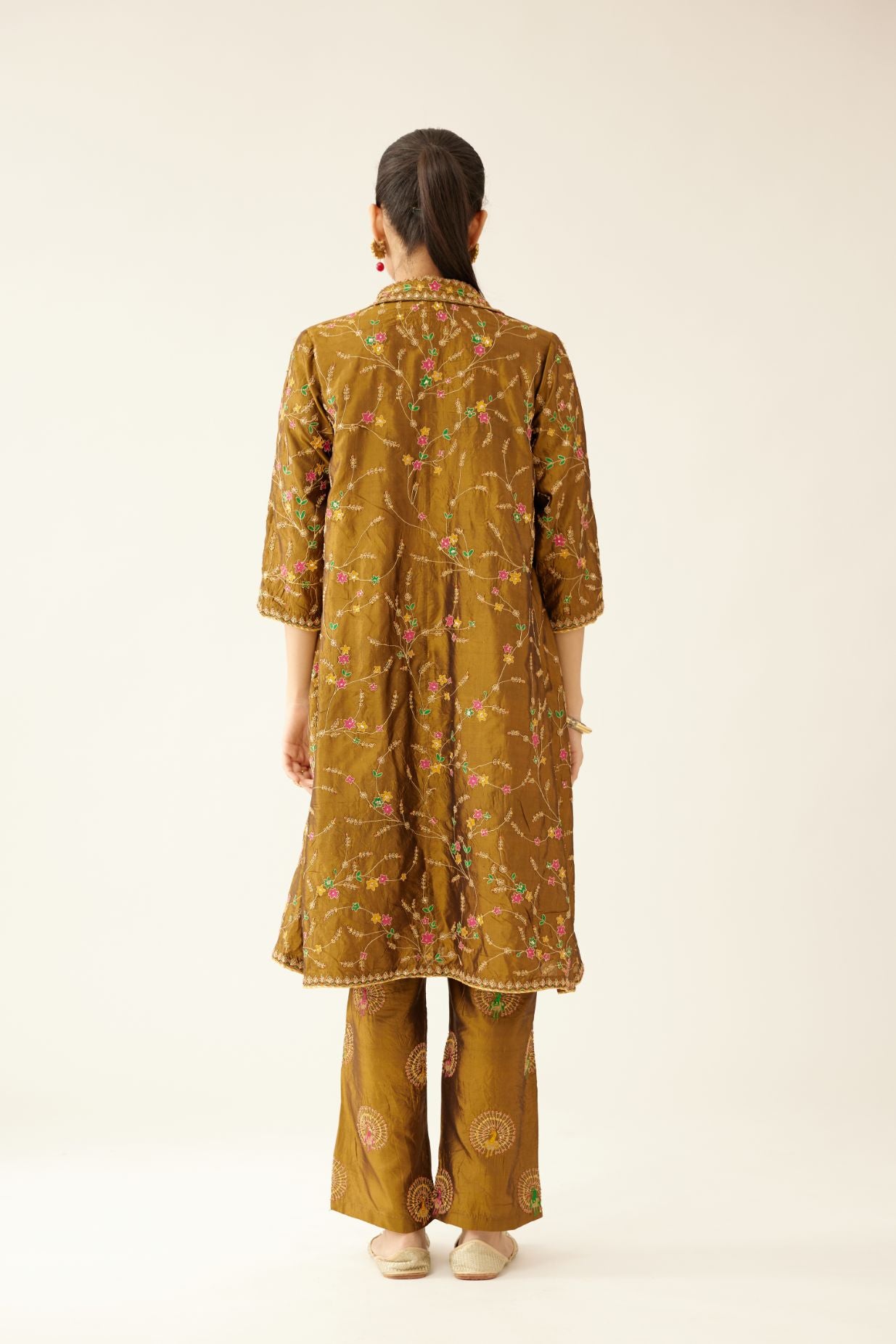 Golden olive A-line short silk kurta set with all over embroidery, highlighted with sequins and bead work, paired with golden olive silk straight pants with dori and silk thread embroidery.
